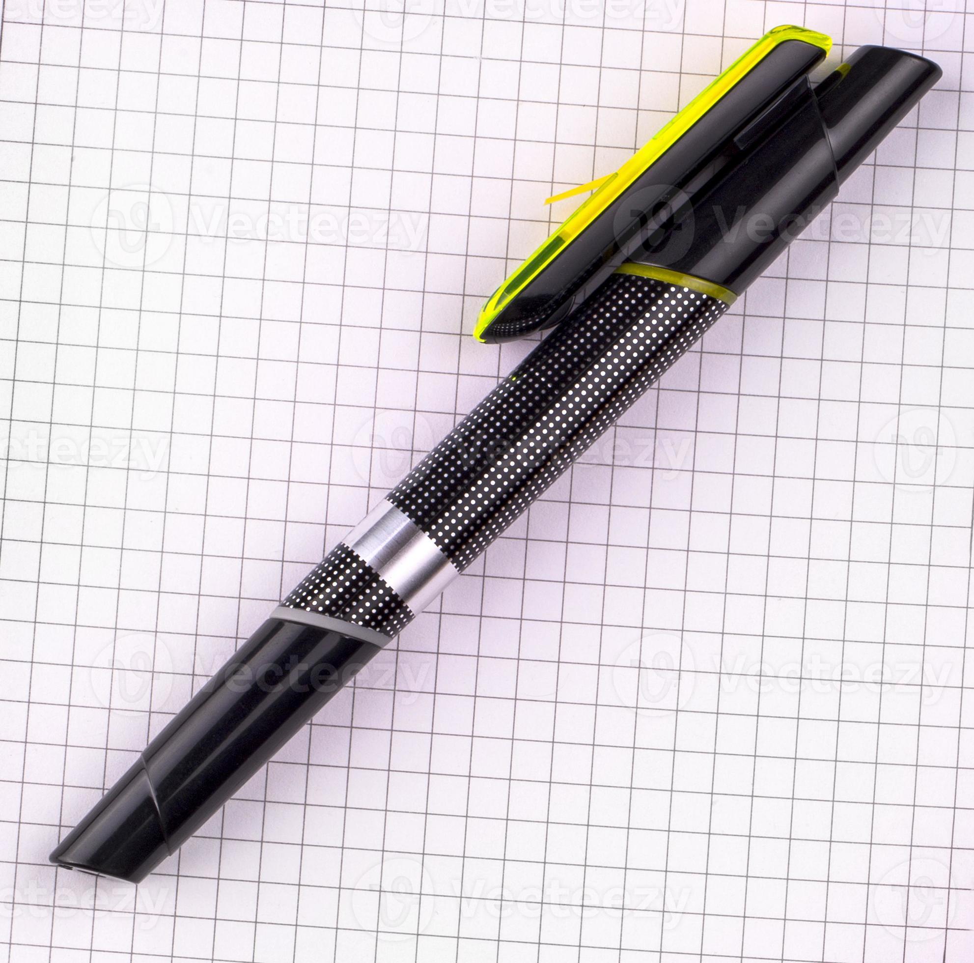stylo noir pour écrire sur du papier cahier à carreaux blanc