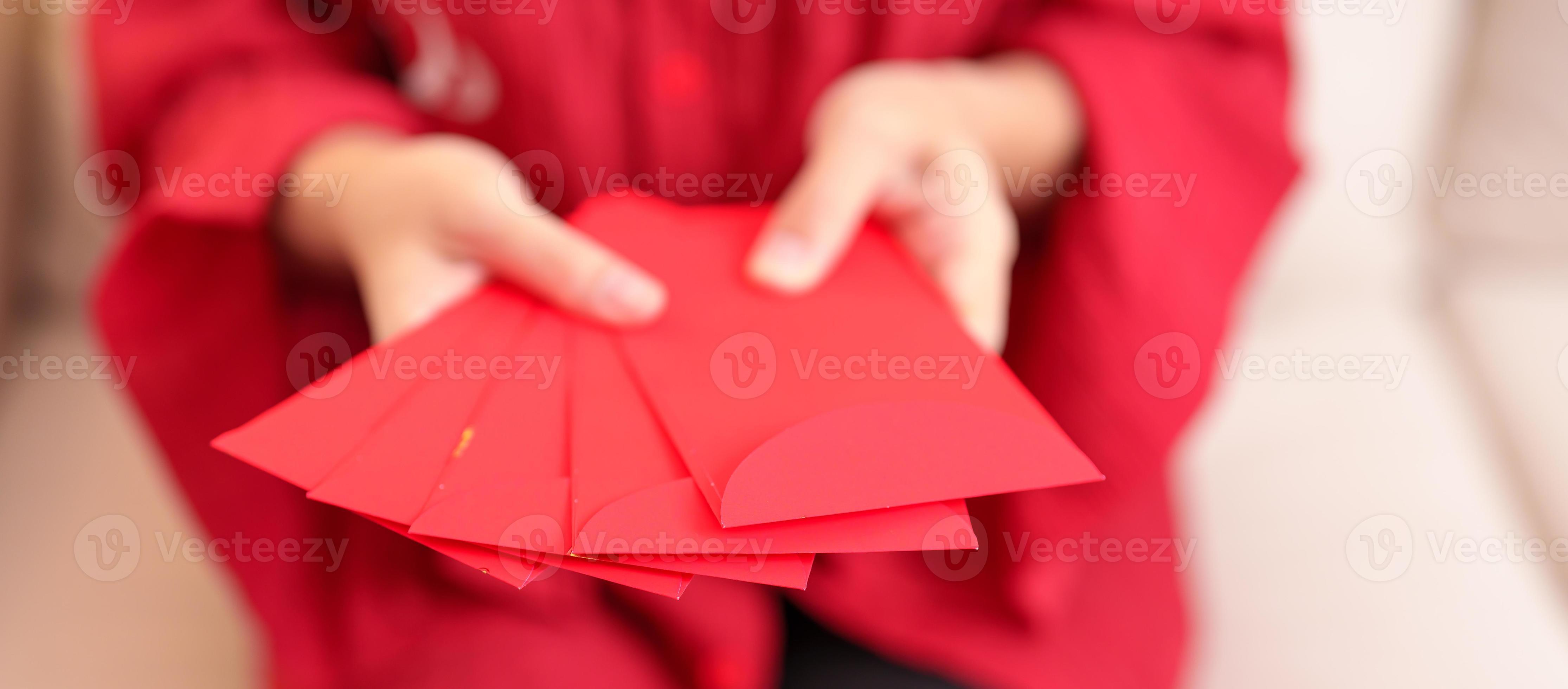 femme tenant une enveloppe rouge chinoise, cadeau en argent pour les  vacances du nouvel an lunaire 17379605 Photo de stock chez Vecteezy