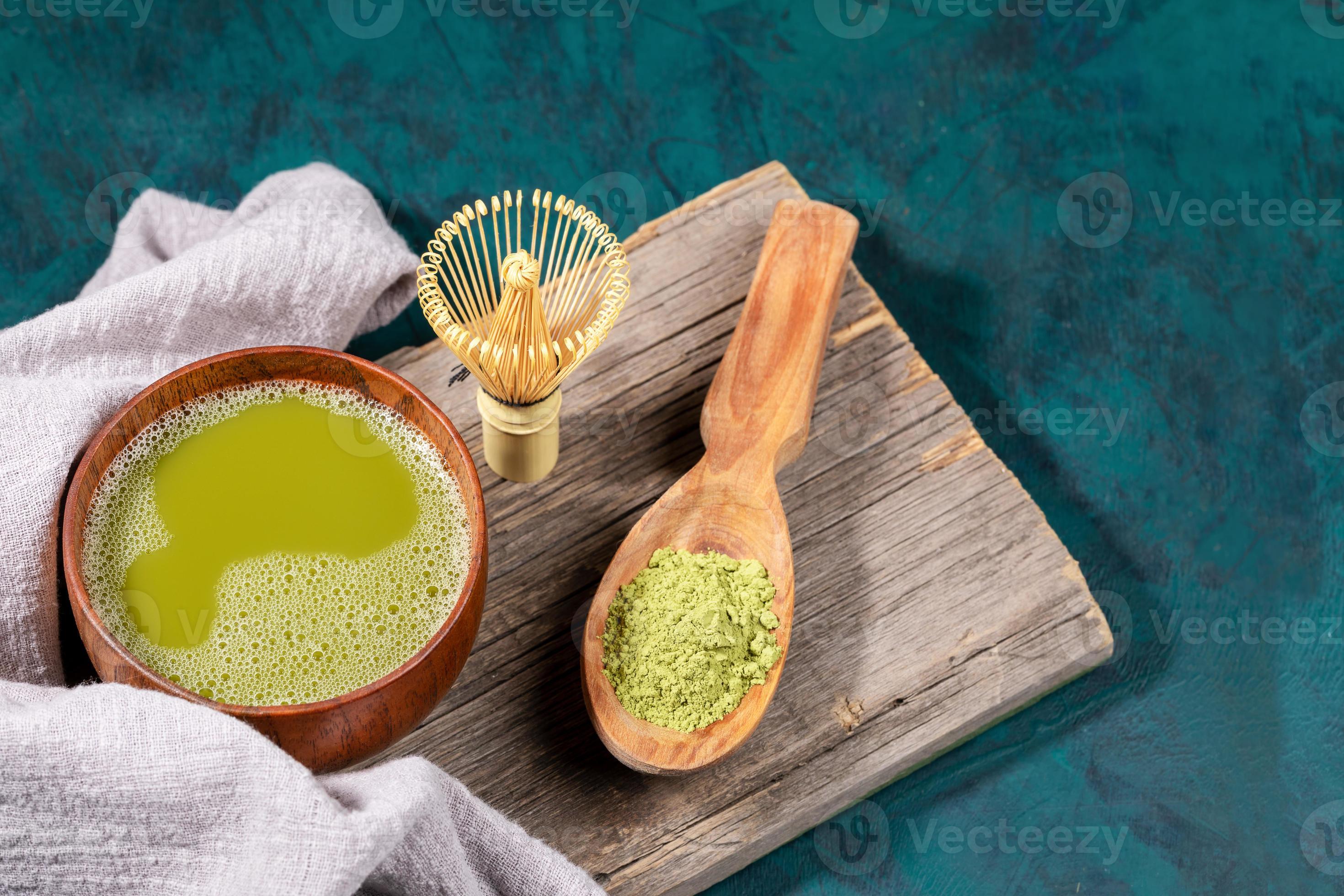 tasse en bois de thé matcha vert, poudre de matcha dans une cuillère en  bois, fouet en bambou sur une vieille planche de bois sur fond émeraude.  17381854 Photo de stock chez