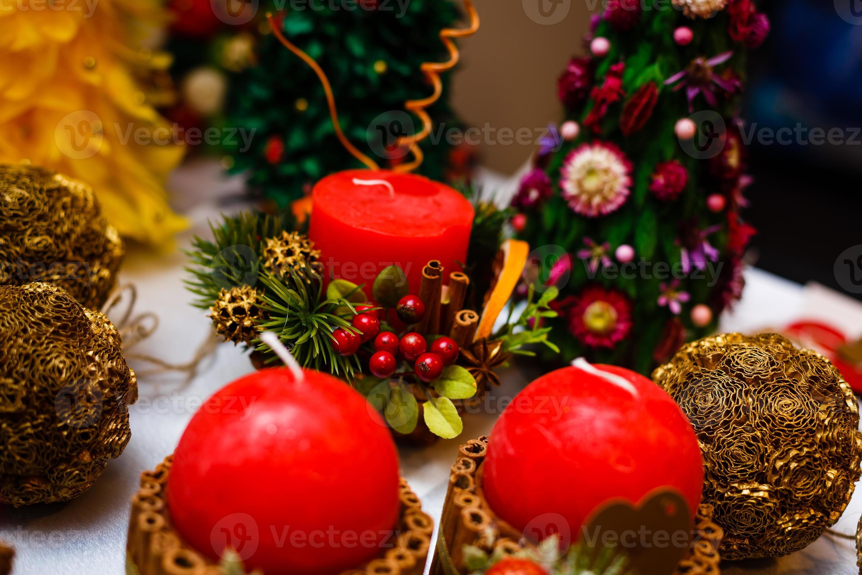 bougie décorée de bâtons de cannelle et de pommes rouges