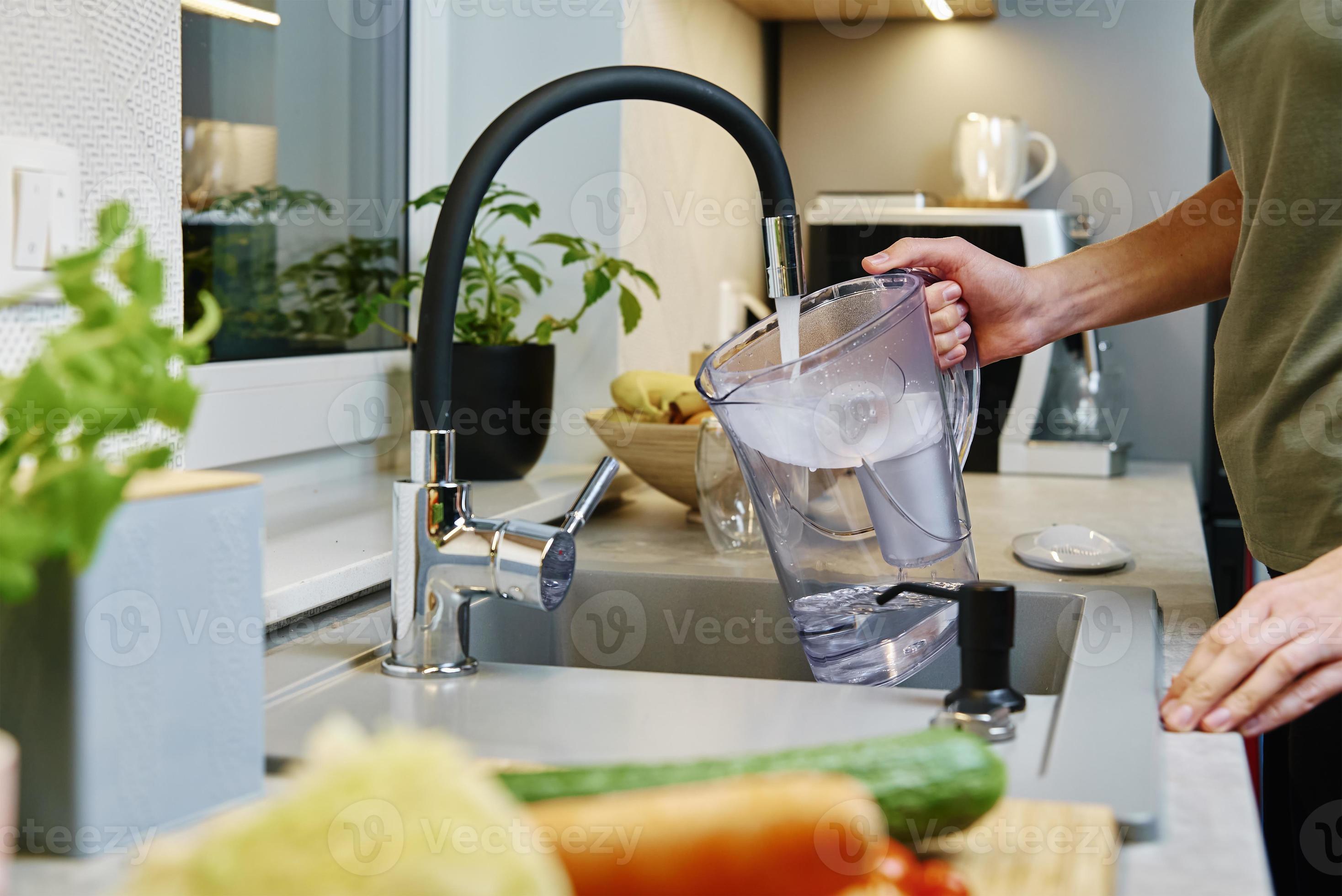 Femme Versant De L'eau Du Robinet Dans Une Bouilloire électrique à