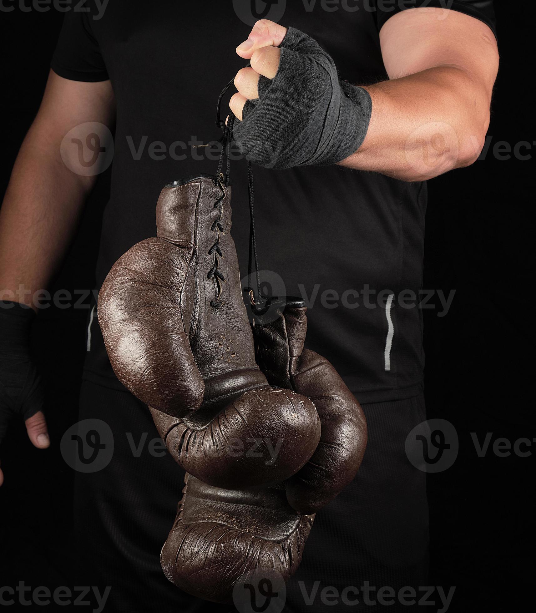 l'athlète en vêtements noirs détient de très vieux gants de boxe