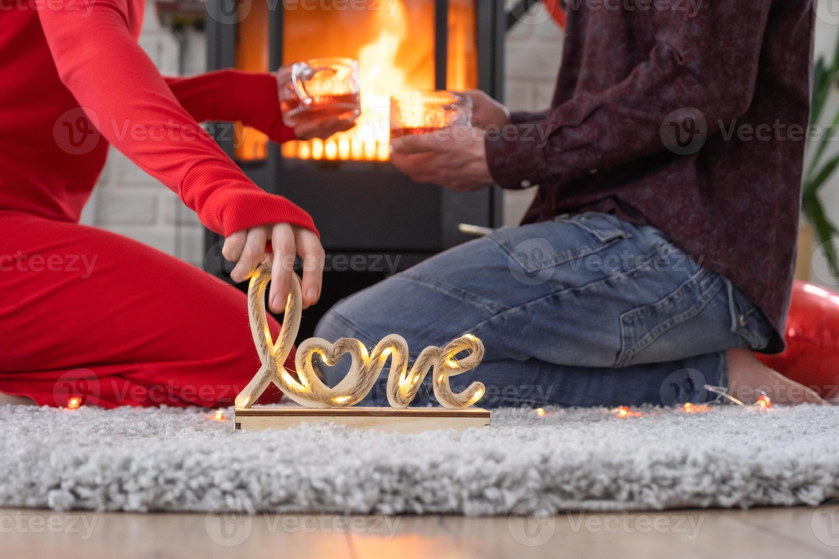 homme et femme amoureux à la maison sont assis près du poêle à