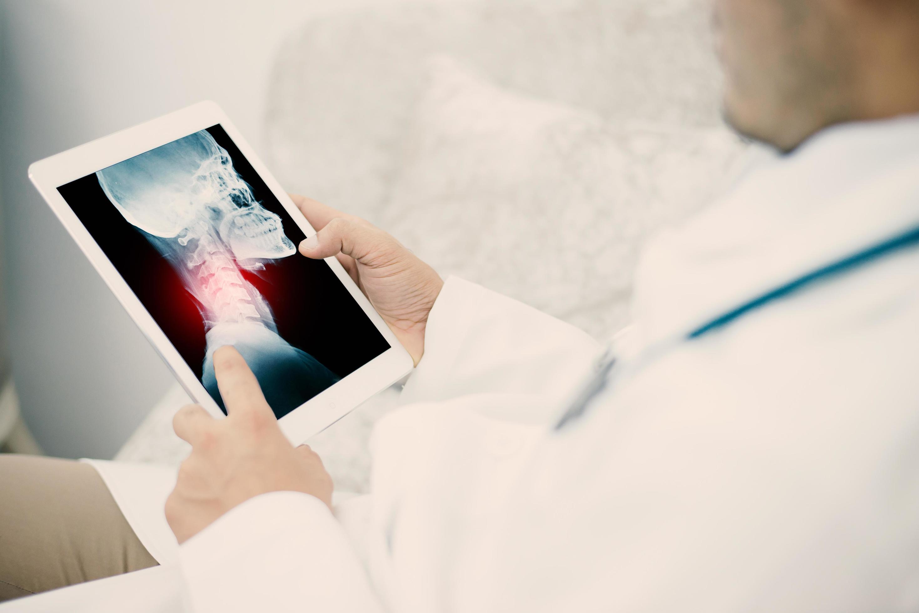 Médecin jeune homme médical explorant radiogramme pulmonaire sur tablette en clinique photo