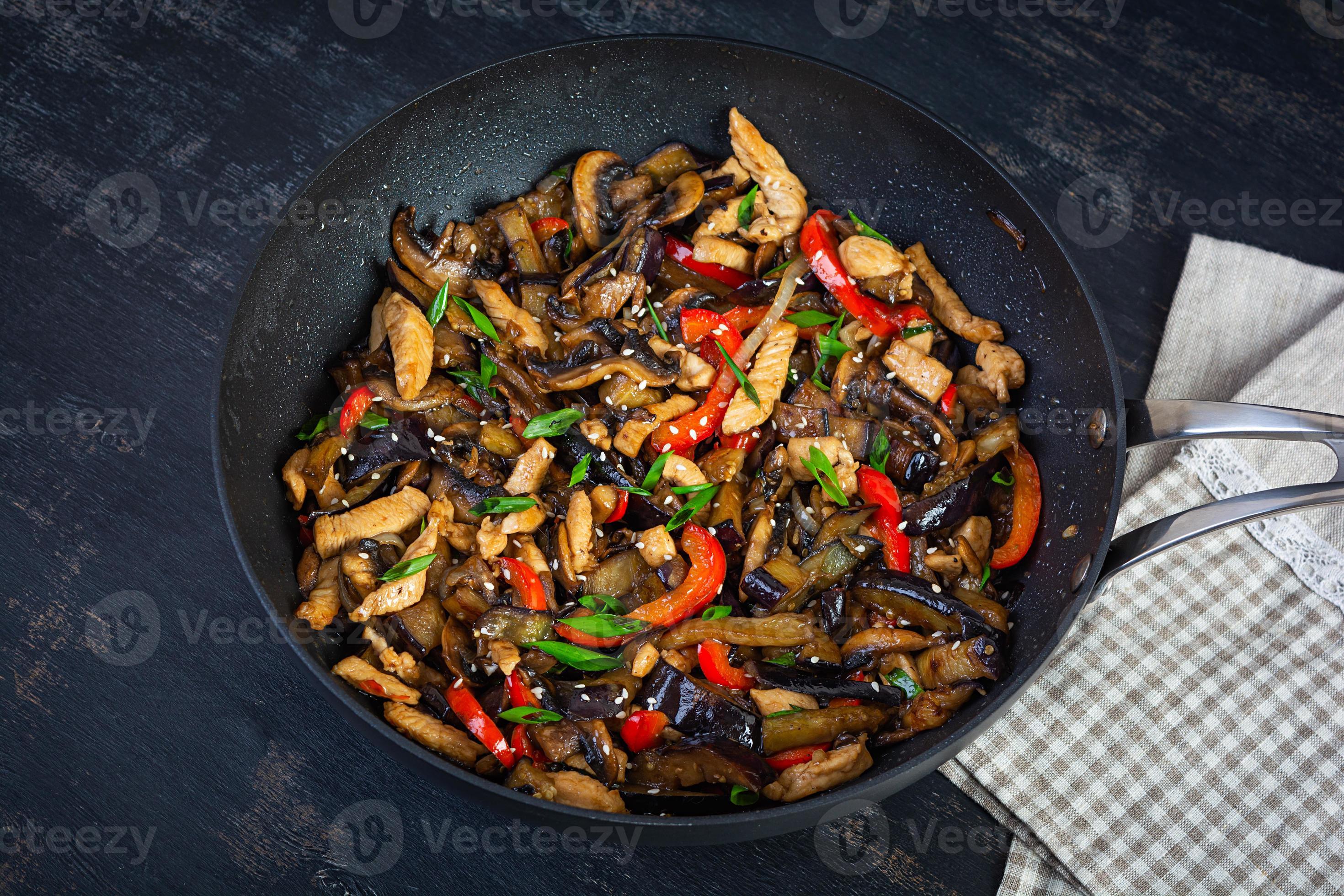 remuer frire avec poulet, aubergine et poivre dans wok la poêle sur foncé  Contexte 20299786 Photo de stock chez Vecteezy