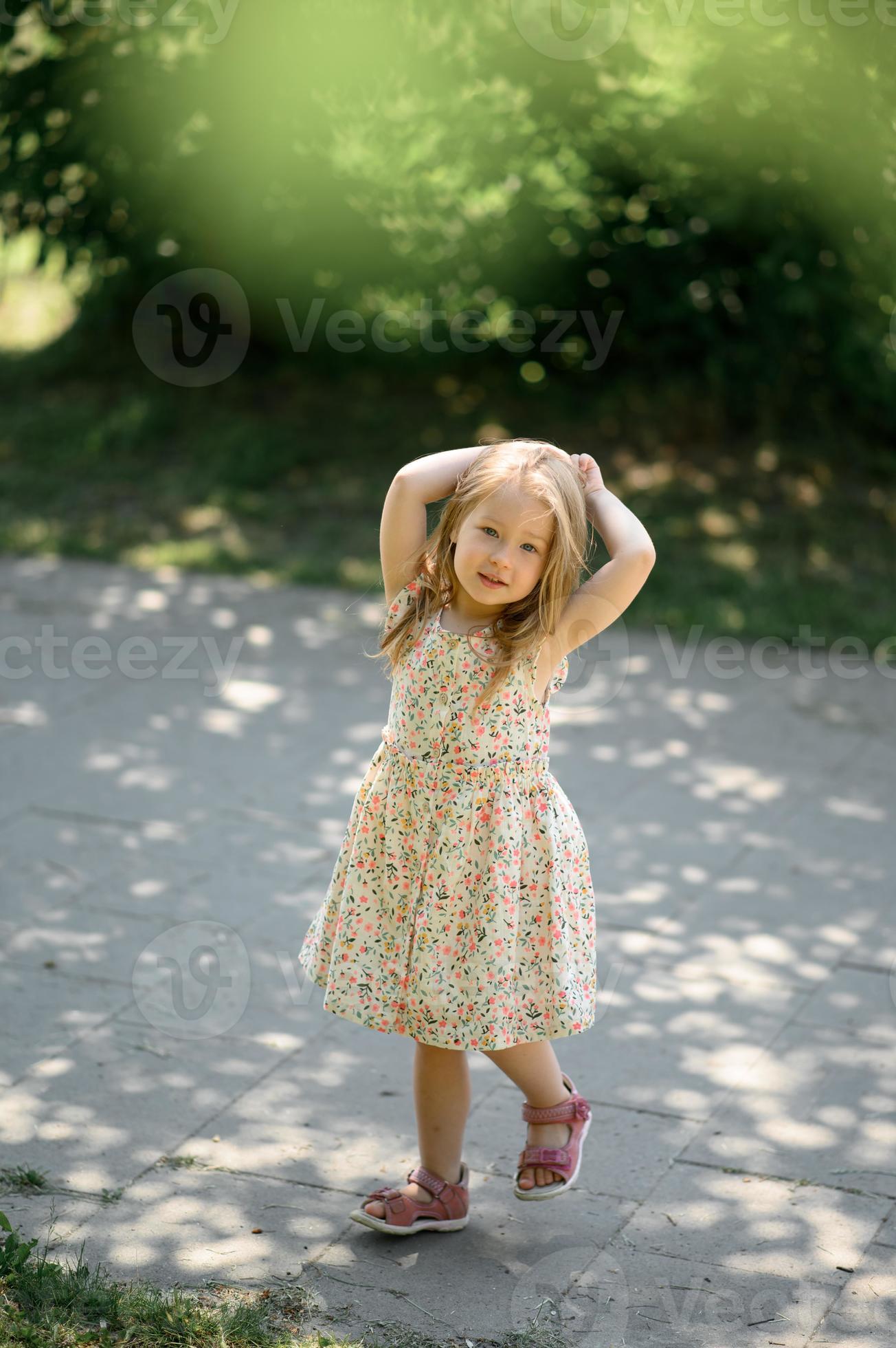 peu fille 3 ans vieux dans une été robe d'été dans le parc. été temps.  21178083 Photo de stock chez Vecteezy