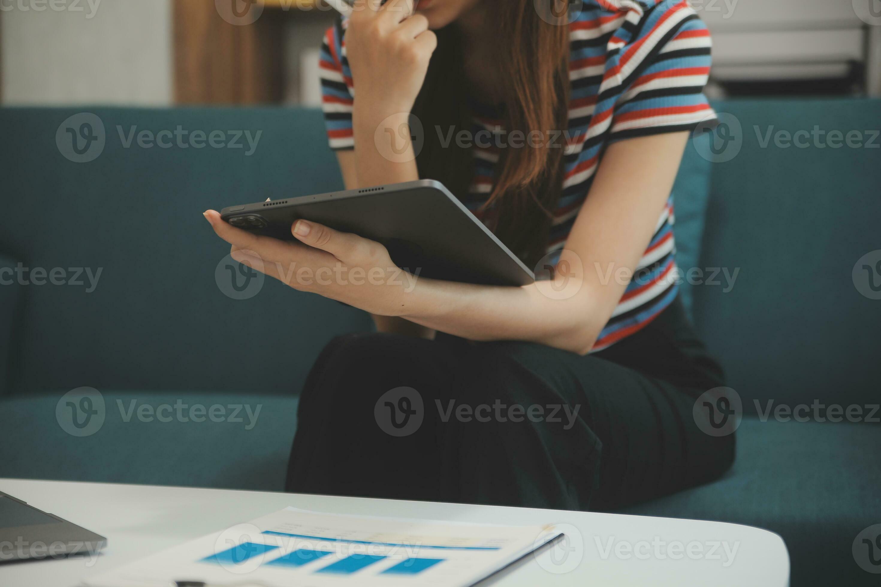 content asiatique adolescent fille en portant tampon ordinateur gadget en  utilisant numérique tablette La technologie séance sur le canapé à maison.  souriant Jeune femme en utilisant applications, achats en ligne, en train