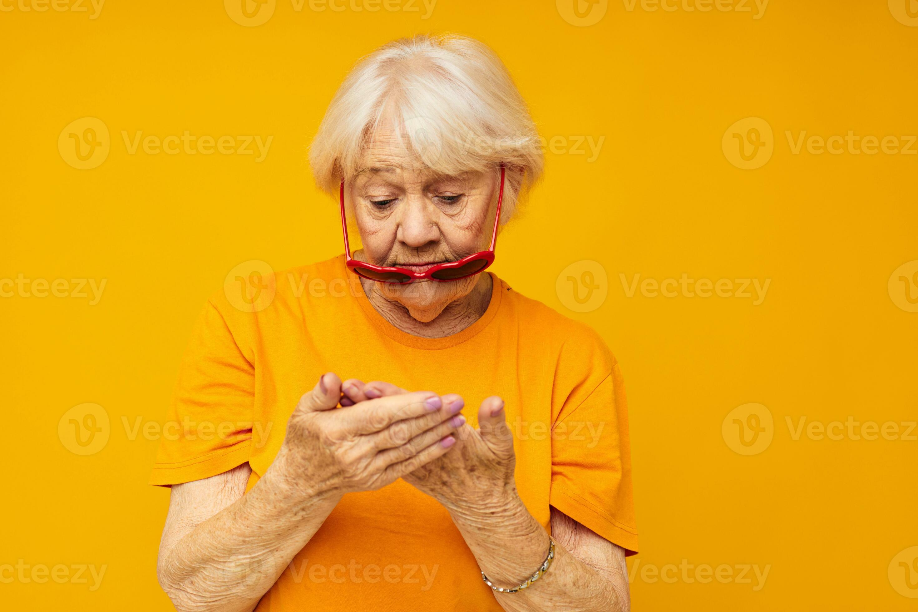 photo de retraité vieux Dame dans foncé des lunettes dans le forme de une cœur  Jaune Contexte 25016404 Photo de stock chez Vecteezy