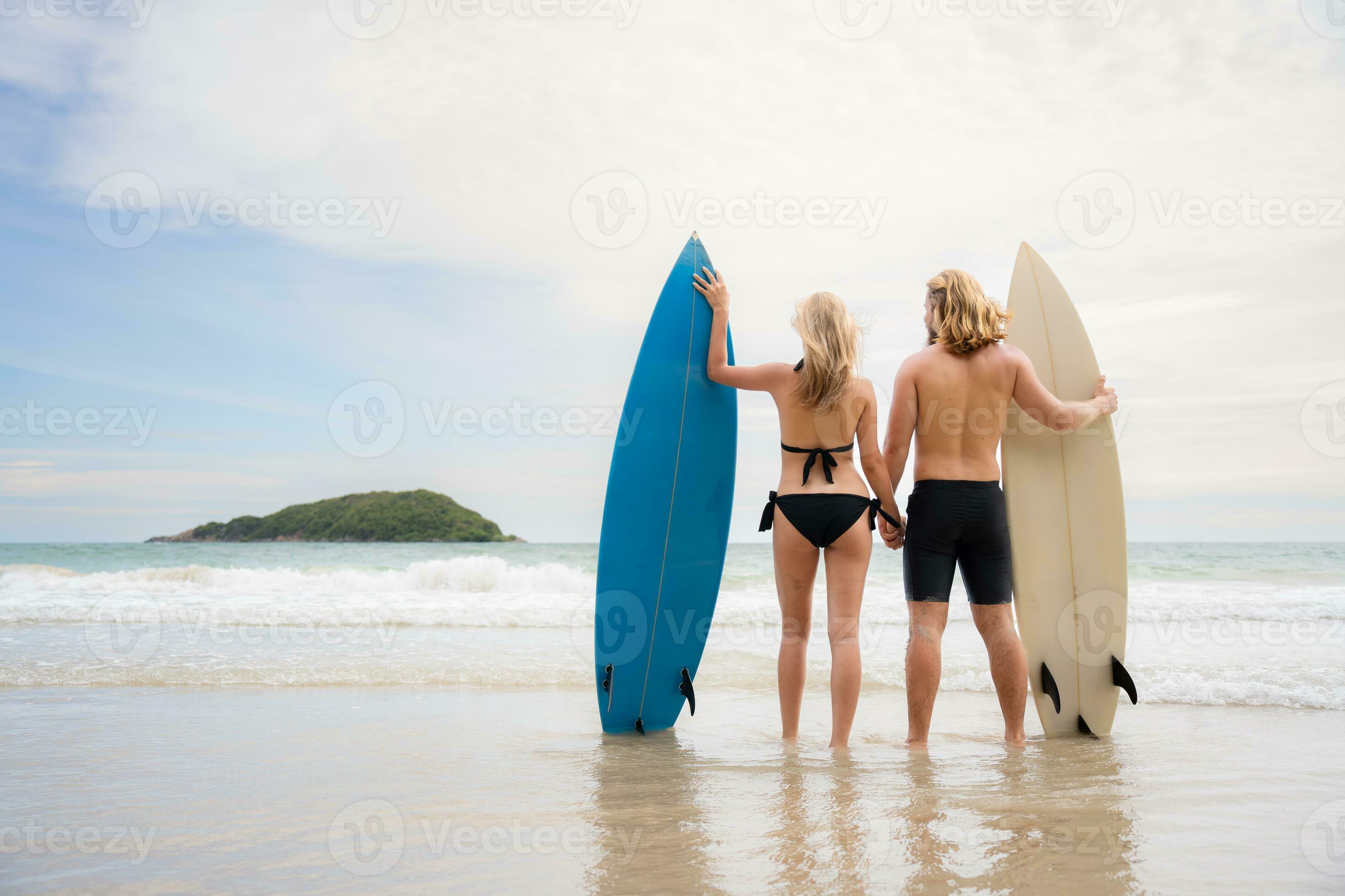 arrière vue de Jeune homme et femme dans maillots de bain avec planches de  surf sur le plage. 31607787 Photo de stock chez Vecteezy