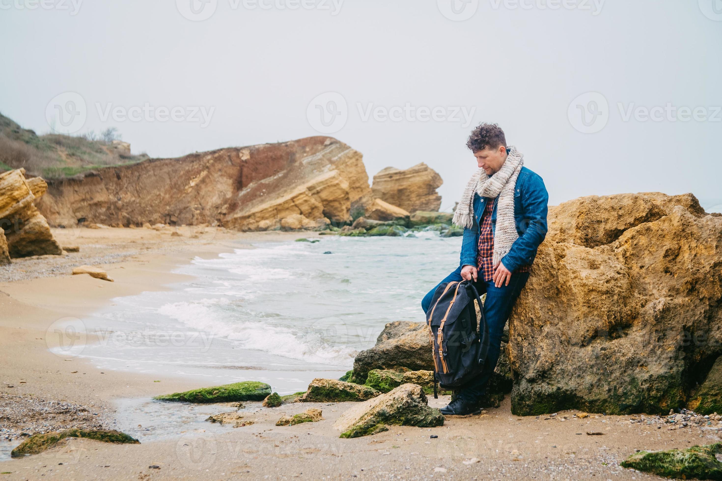 Homme Voyageur Avec Sac À Dos Debout Sur Une Plage De Sable Au Milieu De  Rochers Sur Fond De Mer. Place Pour Le Texte Ou La Publicité. Banque  D'Images et Photos Libres