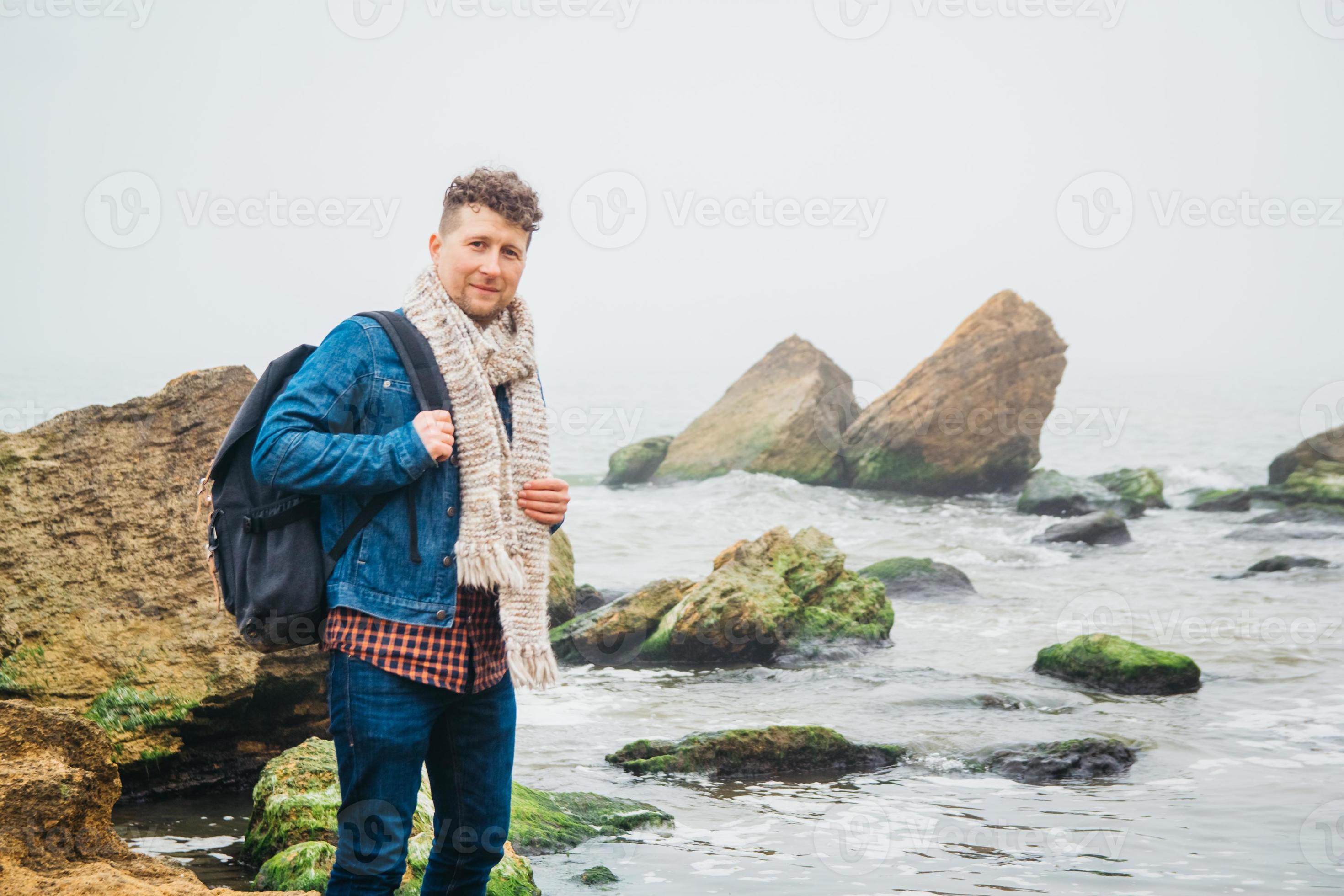 homme voyageur avec sac à dos debout sur une plage de sable au milieu des  rochers sur fond de mer 4888946 Photo de stock chez Vecteezy