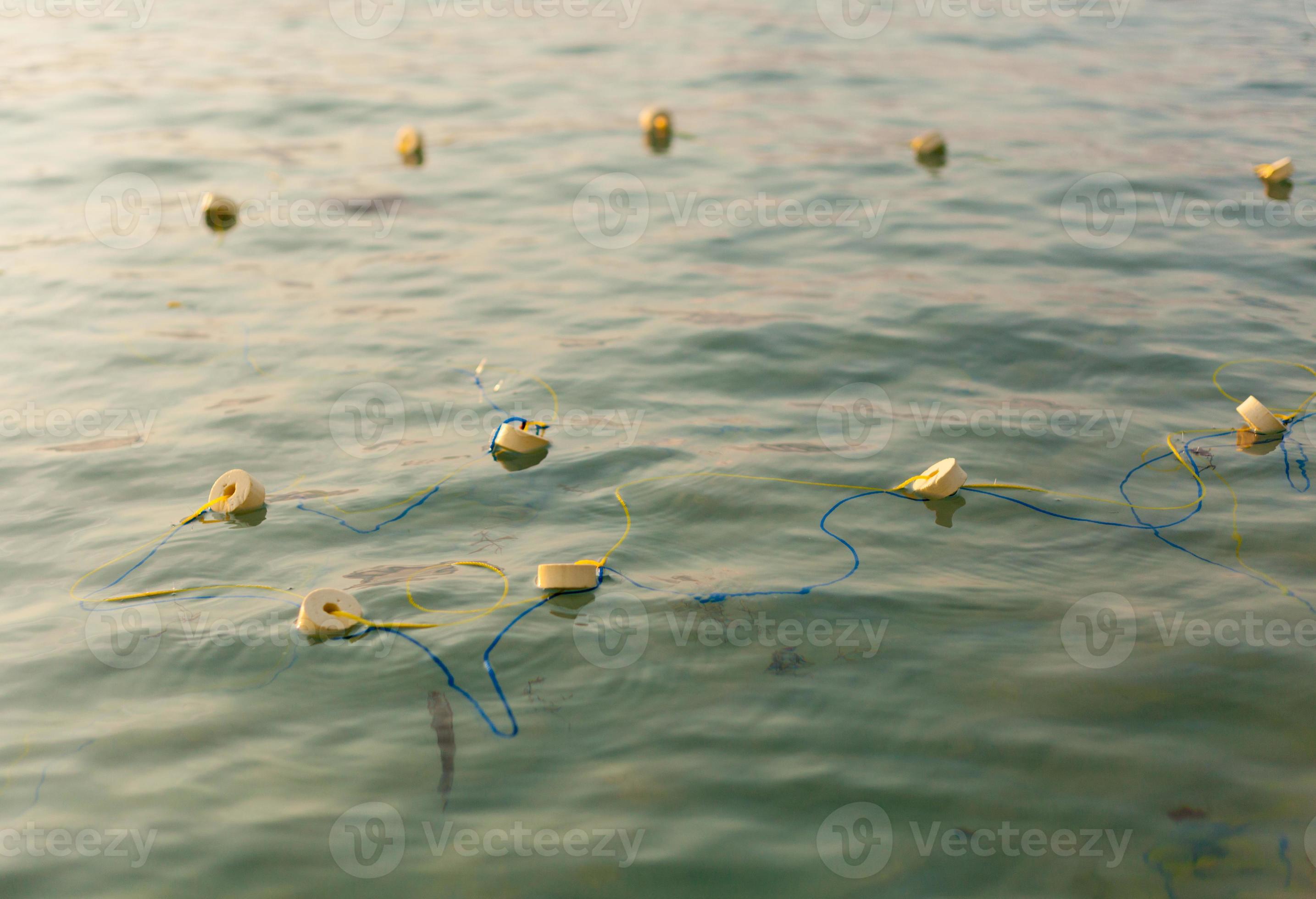 filets de pêche et cordes flottant sur la mer. 5090112 Photo de stock chez  Vecteezy
