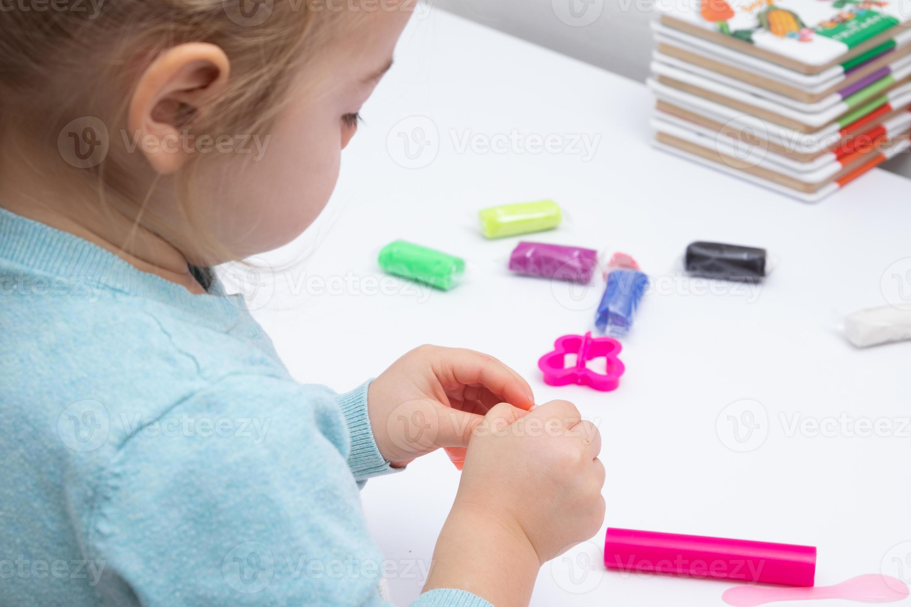 la fille à table joue avec de la pâte à modeler. jeux pour enfants pour la  motricité fine 5713926 Photo de stock chez Vecteezy