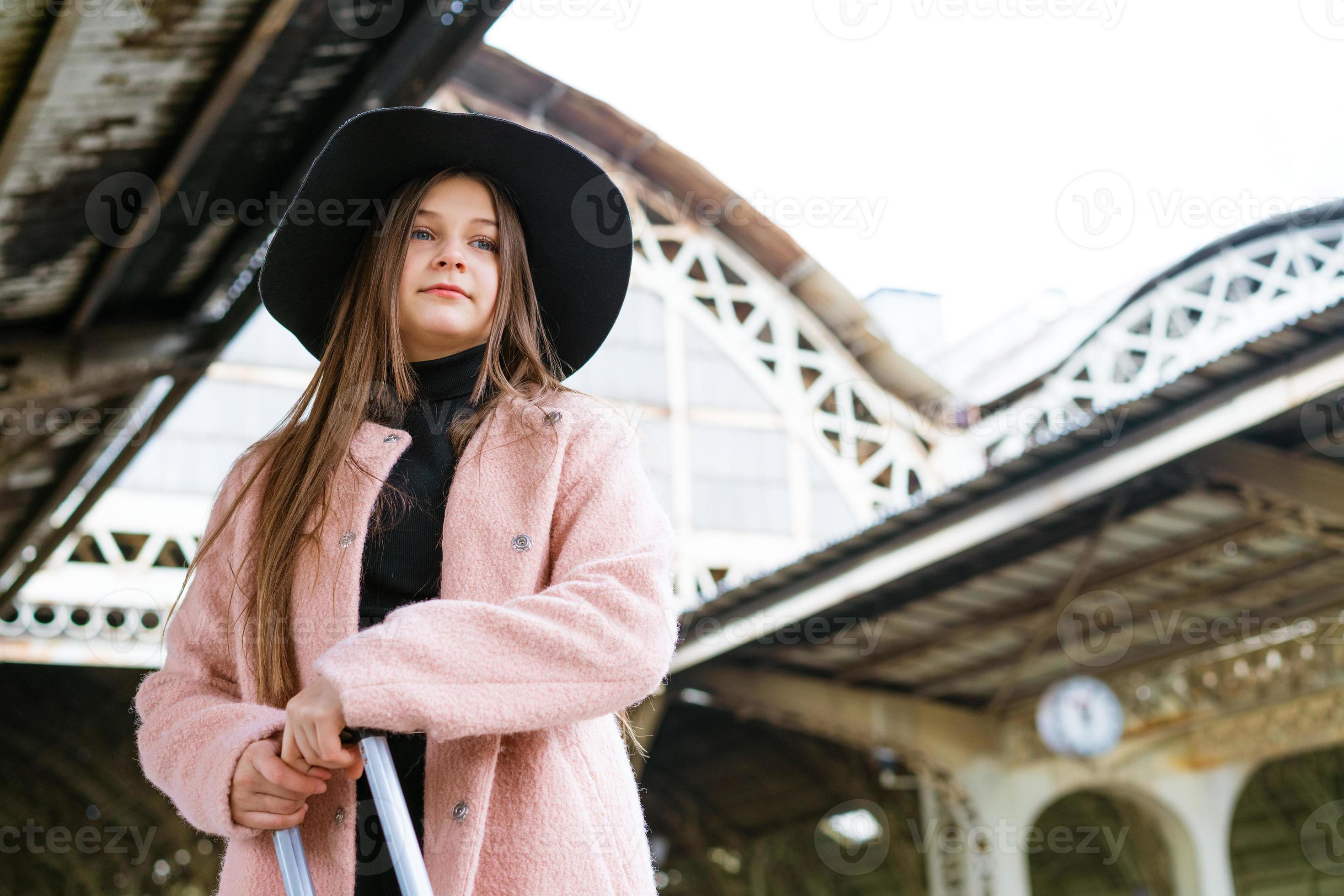jeune femme avec valise sur le quai de la gare. fille de voyageur en attente photo