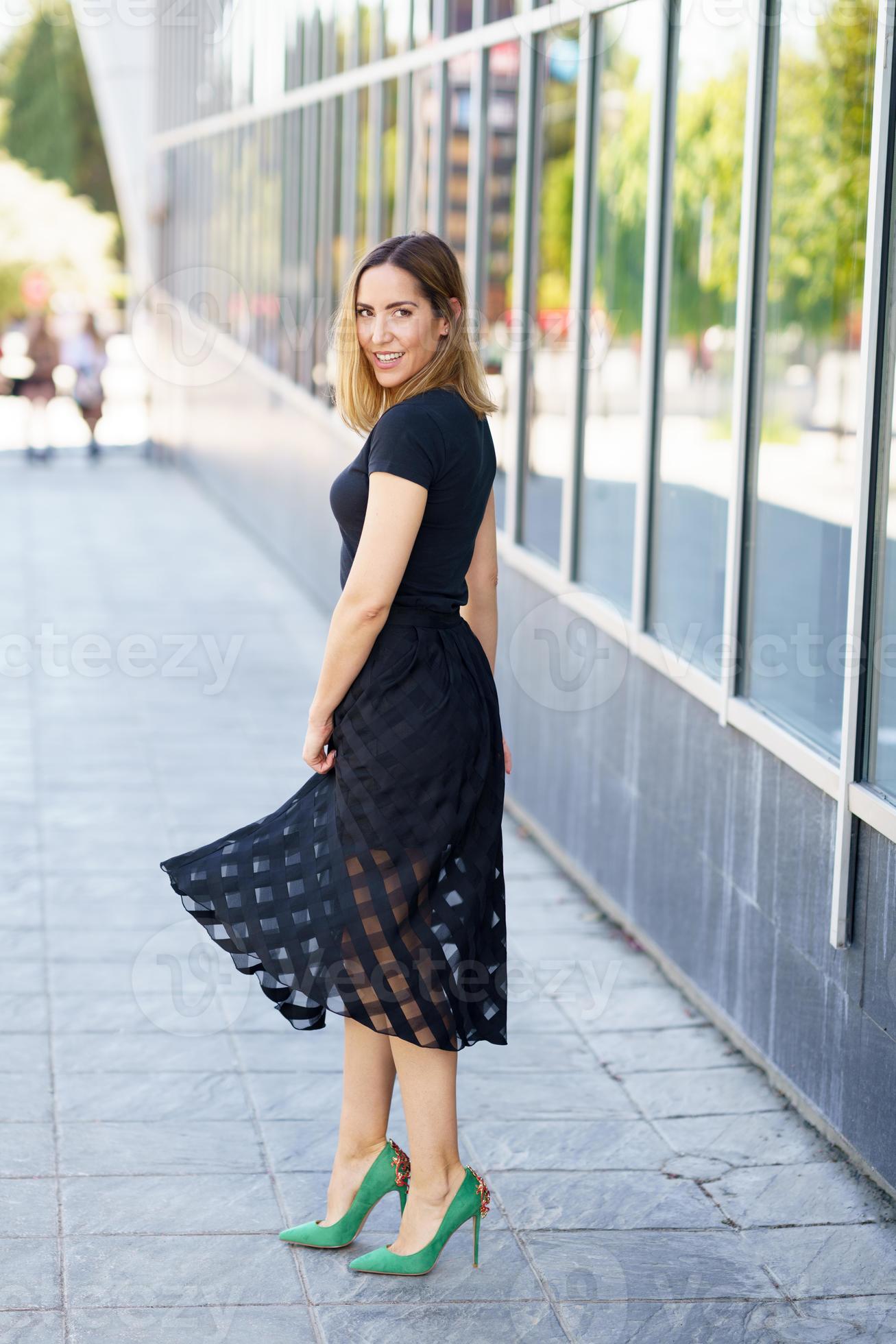 jolie femme portant une jupe et des talons hauts verts à l'extérieur.  5889871 Photo de stock chez Vecteezy