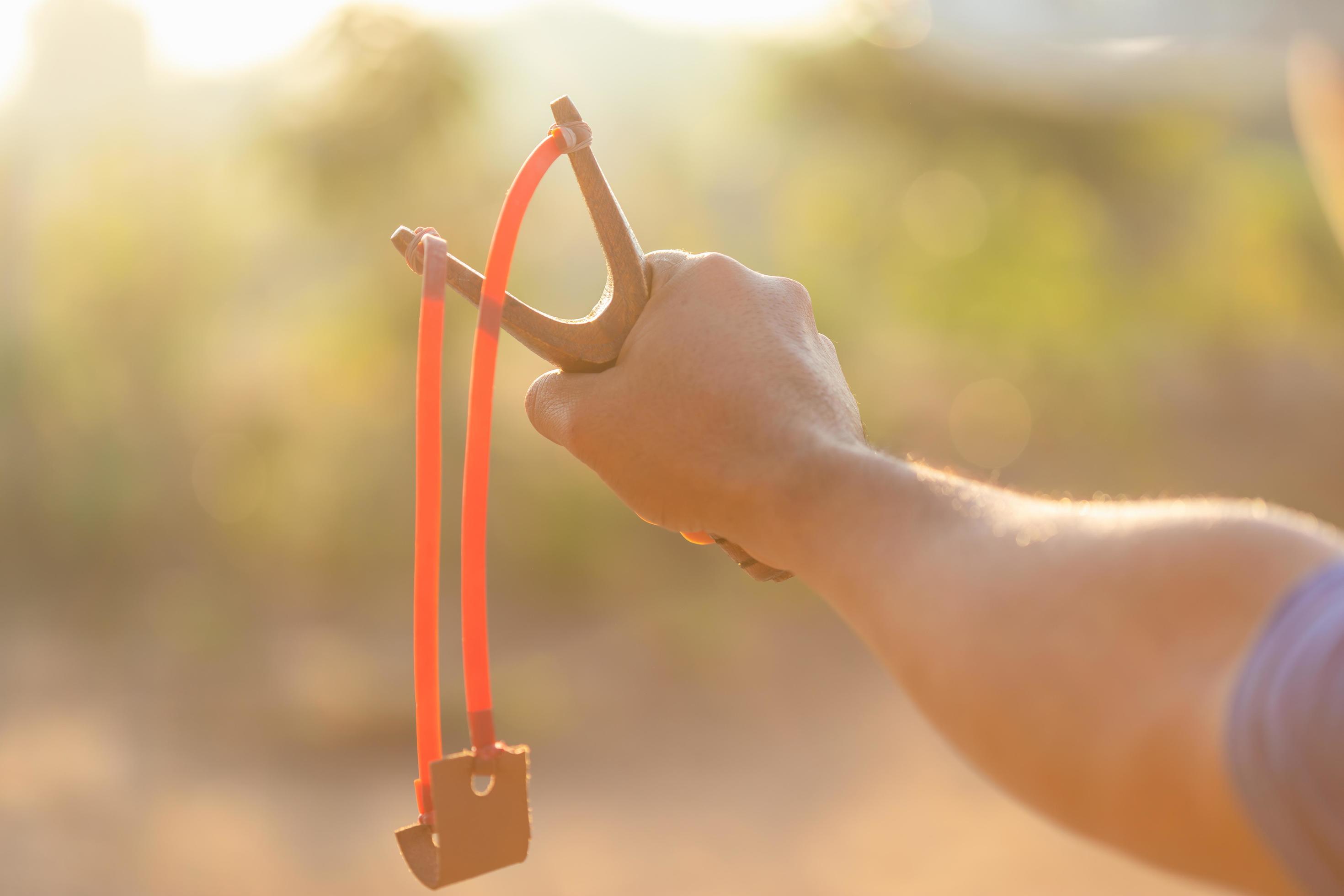 homme jouant à la fronde ou à la catapulte le matin avec effet de lumière  du soleil 6037272 Photo de stock chez Vecteezy