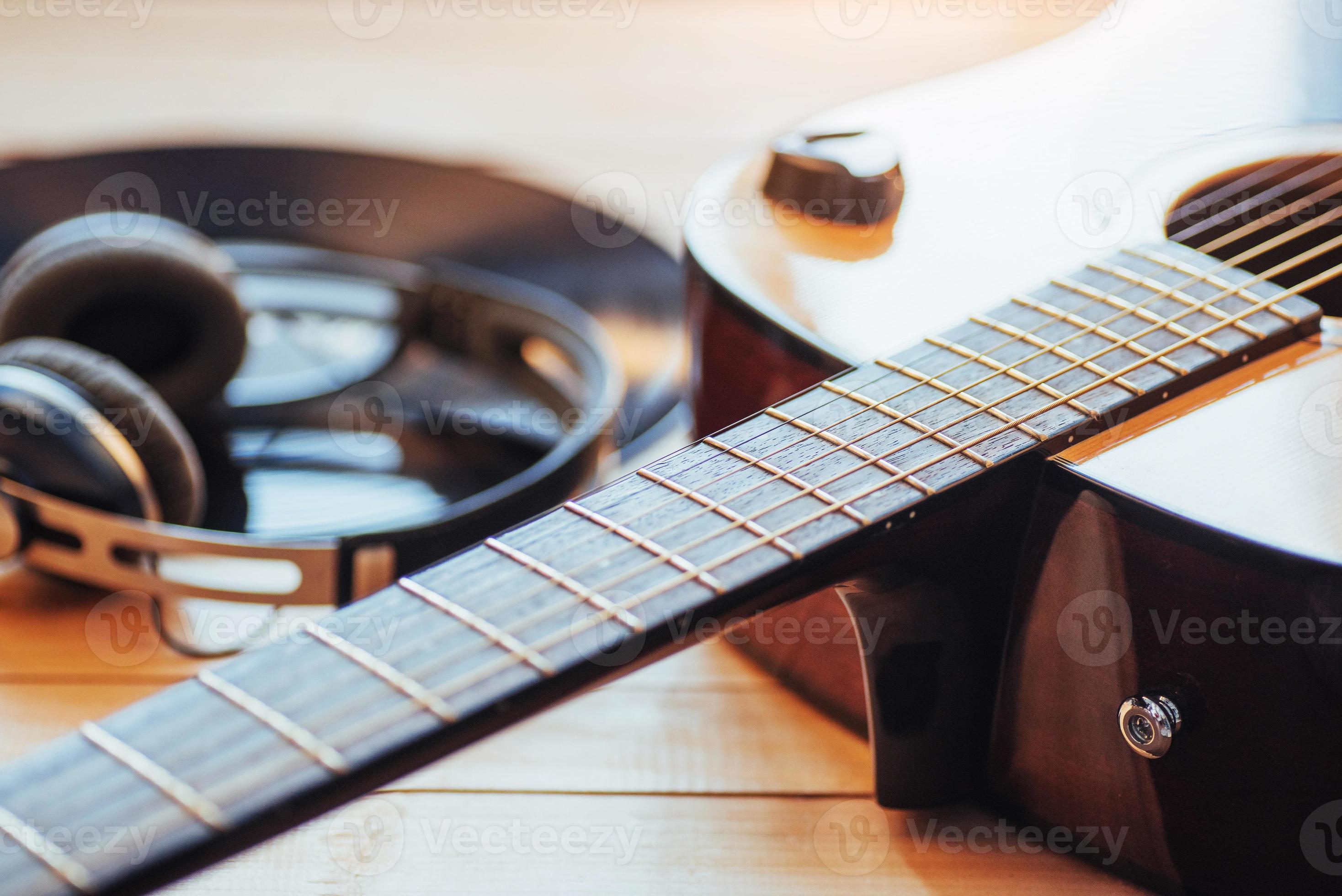 guitare classique avec des écouteurs sur un fond en bois 6175117 Photo de  stock chez Vecteezy