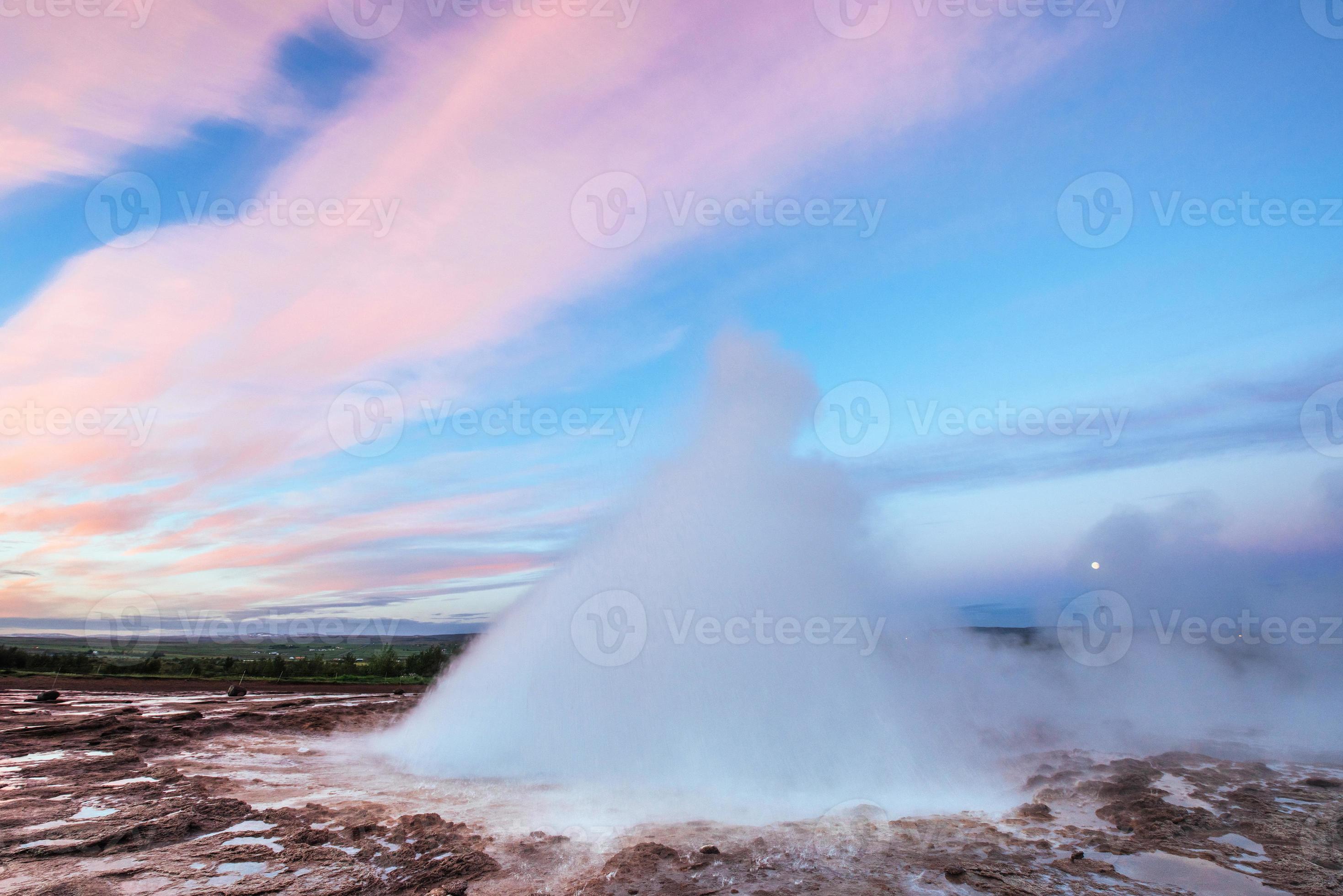 éruption du geyser de strokkur en islande. des couleurs fantastiques brillent à travers photo