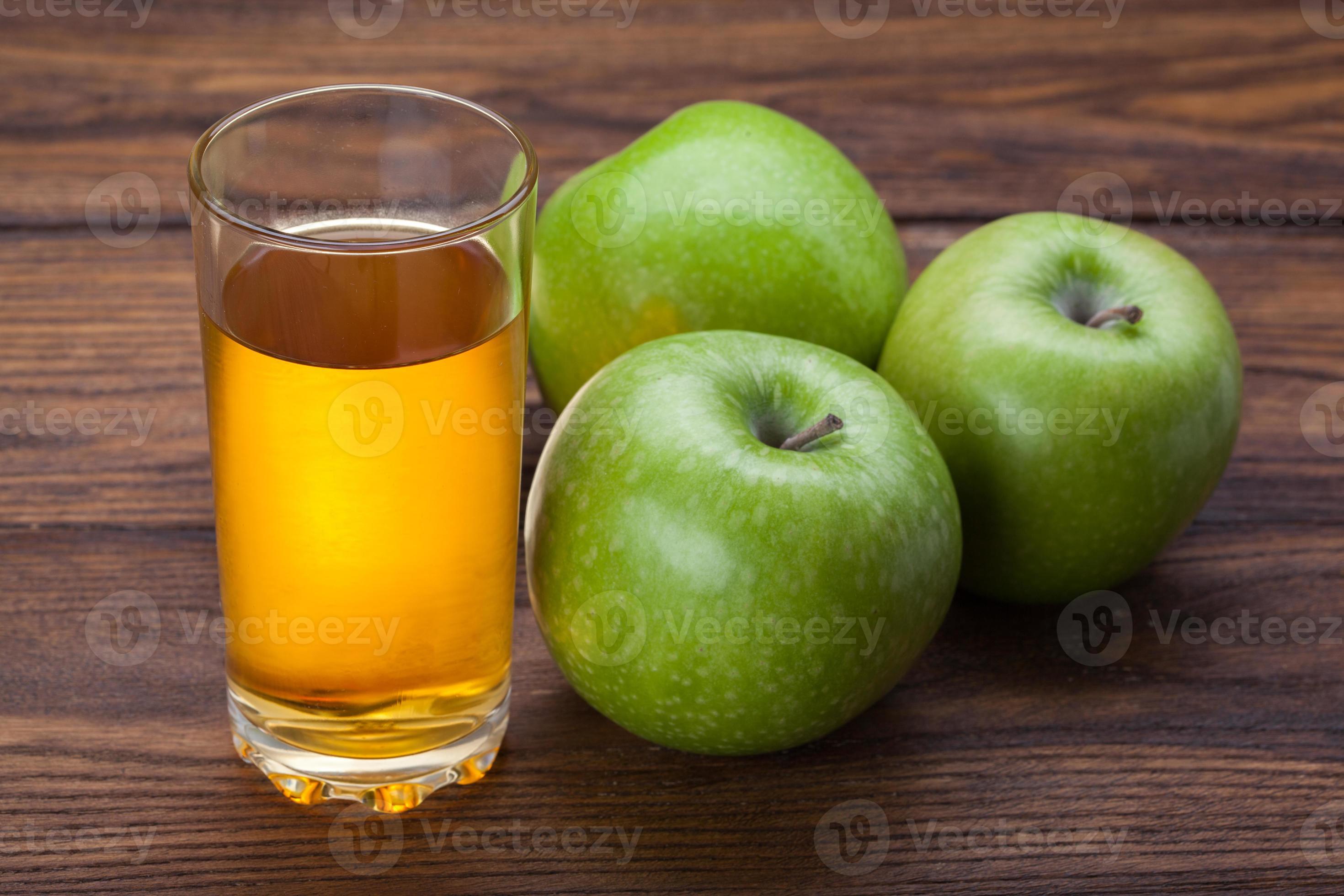 verre de jus de pomme et pommes sur bois photo