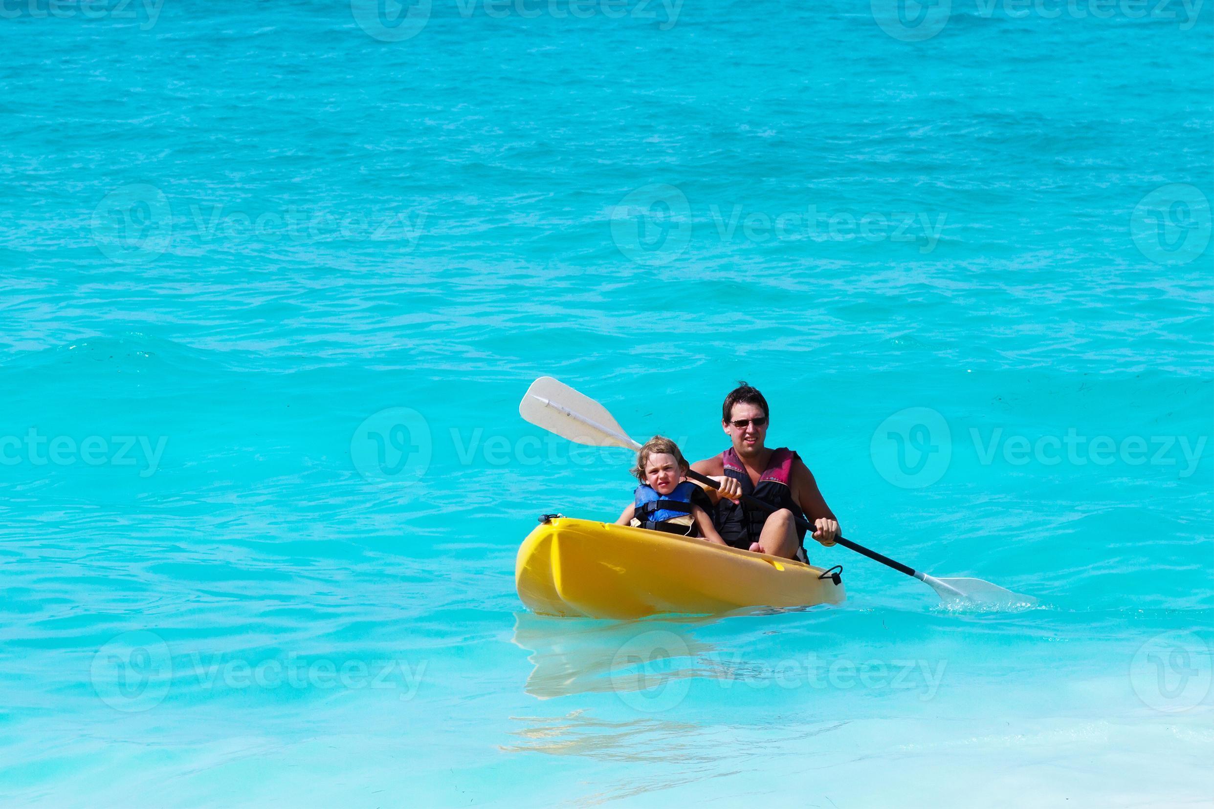 père et fils sur un kayak dans l'océan tropical photo
