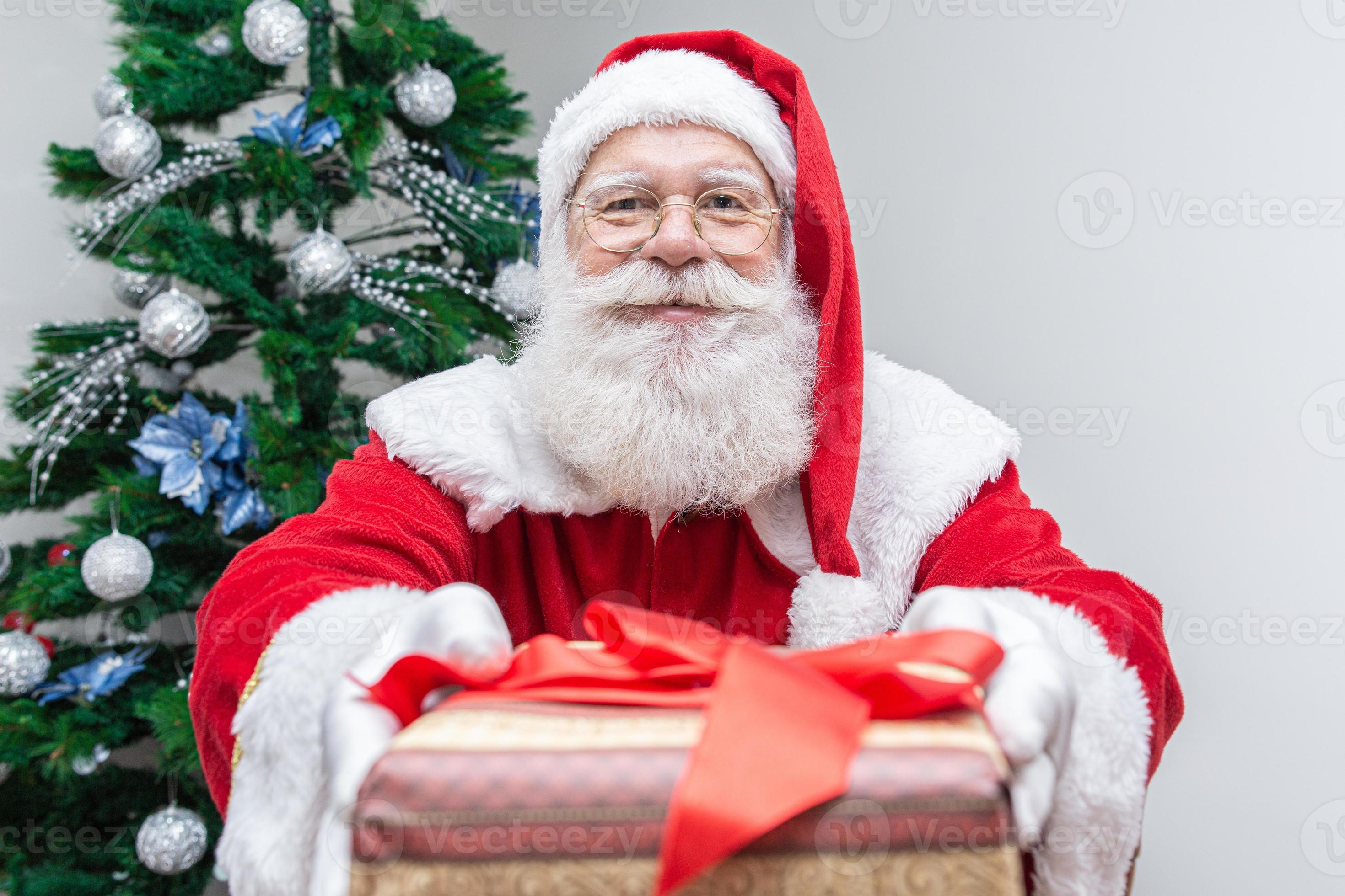 le père noël offrant un cadeau à la caméra. recevoir des cadeaux de Noël.  fêtes du nouvel an. 7717631 Photo de stock chez Vecteezy