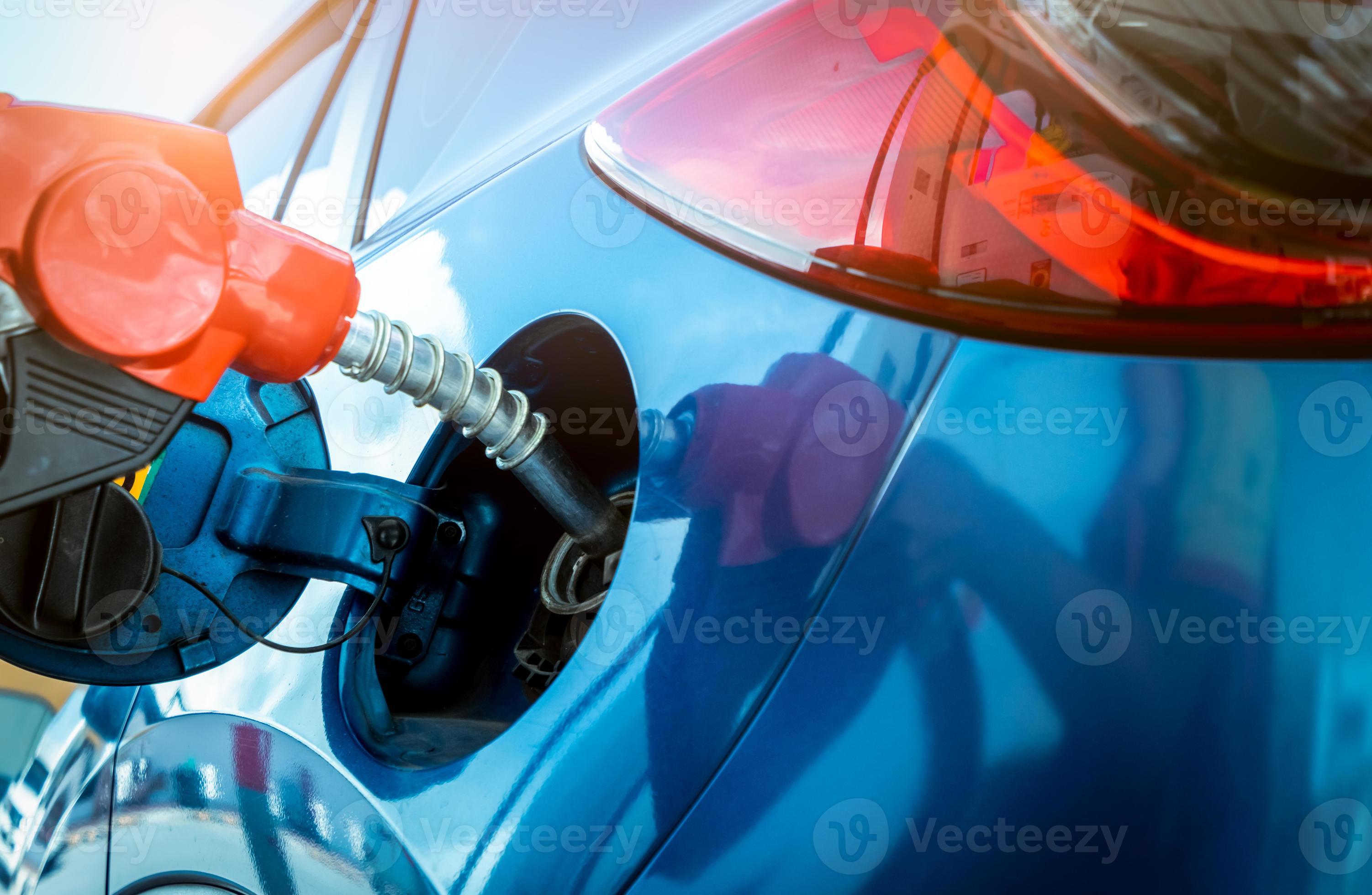 ravitaillement en voiture à la station-service. faire le plein d'essence  essence. pompe à essence remplissant la buse de carburant dans le réservoir  de carburant de la voiture à la station-service. industrie et