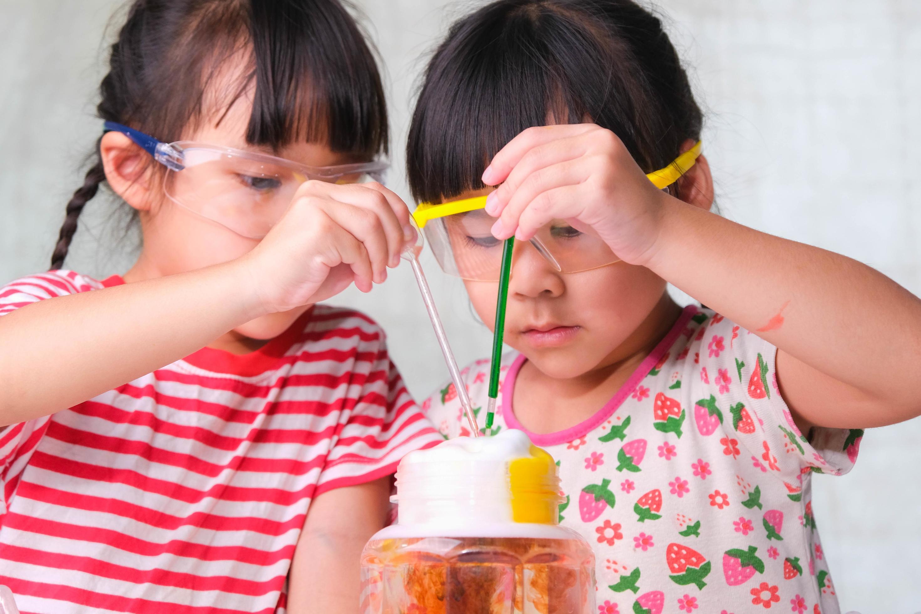 les enfants apprennent et font des expériences scientifiques en classe.  deux petites soeurs jouant à l'expérience scientifique pour l'enseignement  à domicile. des expériences scientifiques faciles et amusantes pour les  enfants à la