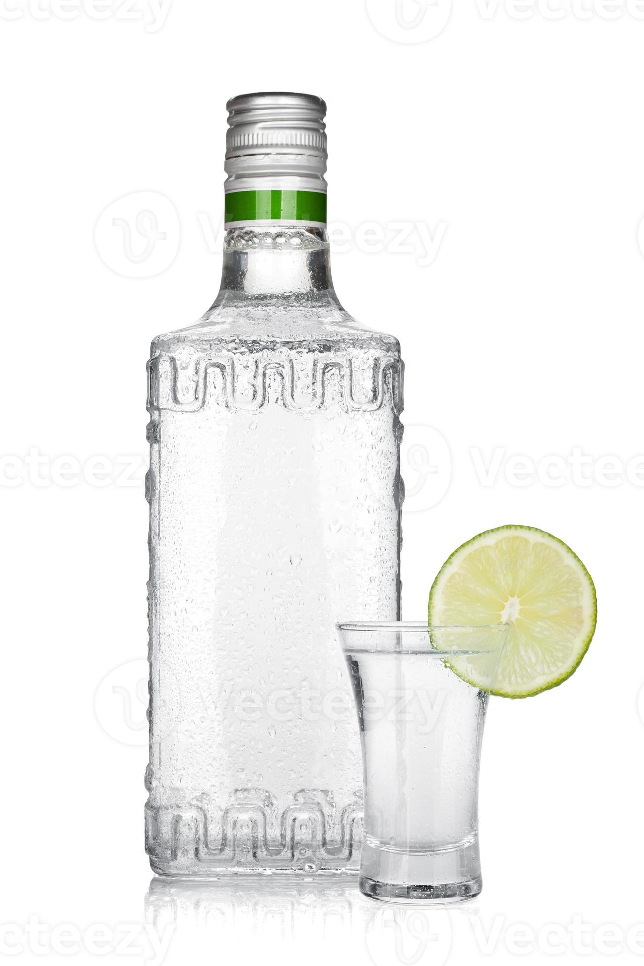 bouteille de tequila en argent et tourné avec une tranche de citron vert photo