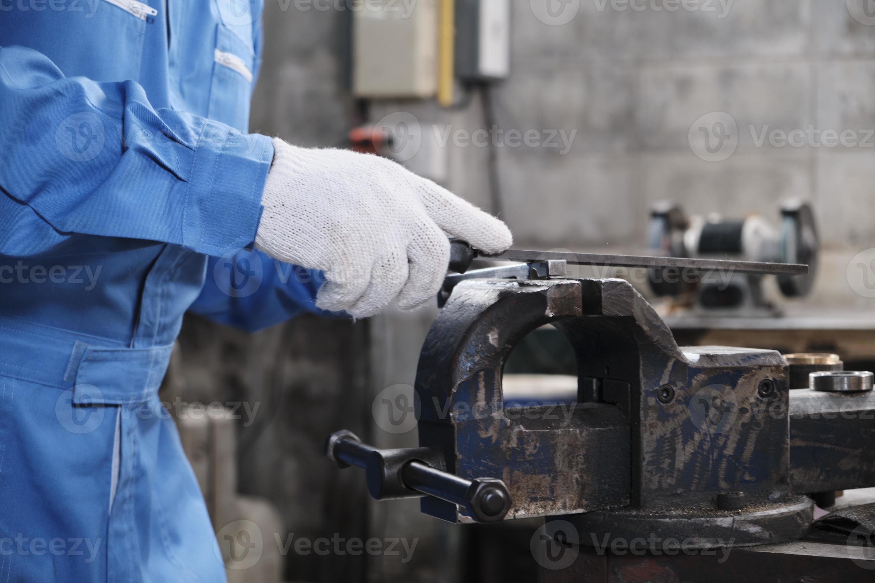 gros plan sur les mains d'un travailleur masculin de l'industrie  professionnelle avec des gants de protection travaille avec des outils de  précision pour la métallurgie, des tours mécaniques et un atelier de