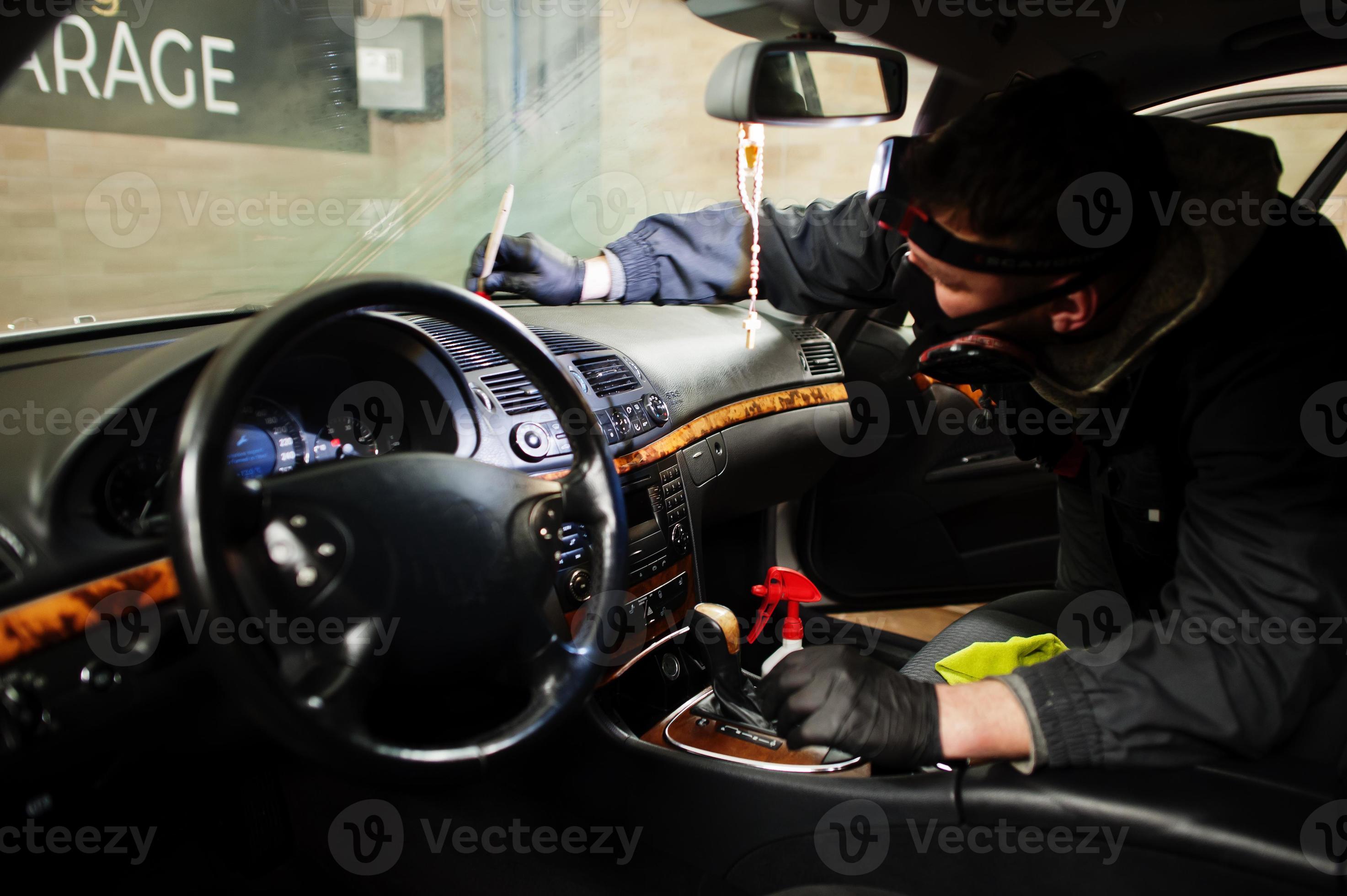 homme en uniforme et respirateur, travailleur du centre de lavage de voiture,  nettoyage de la brosse de nettoyage intérieur de la voiture. concept de  détail de voiture. 8661439 Photo de stock chez