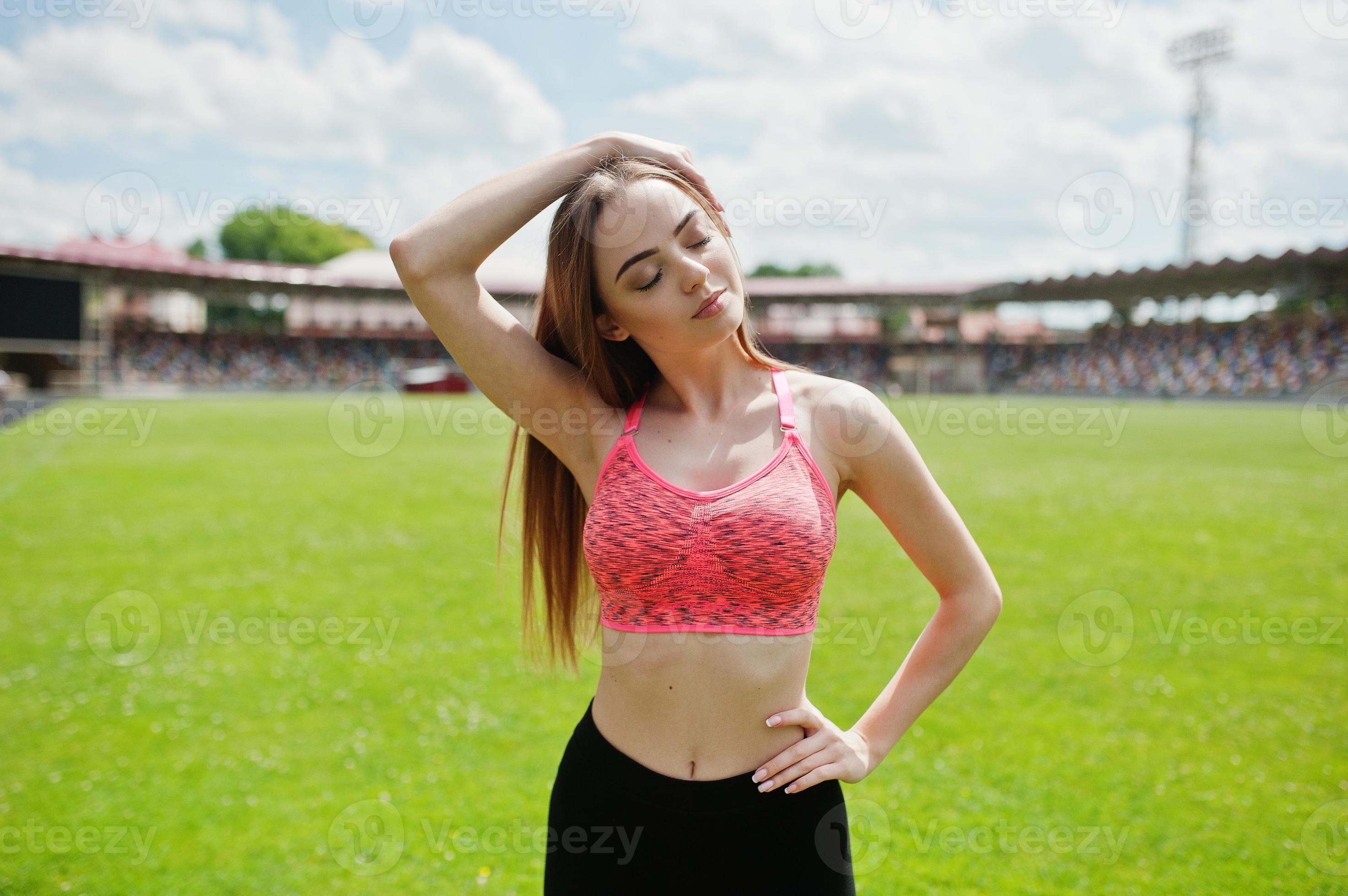 fitness fille sportive en tenue de sport dans un stade de football sports  de plein air. séance d'entraînement de femme sexy heureuse sur le fond de  l'herbe verte. 8676613 Photo de stock