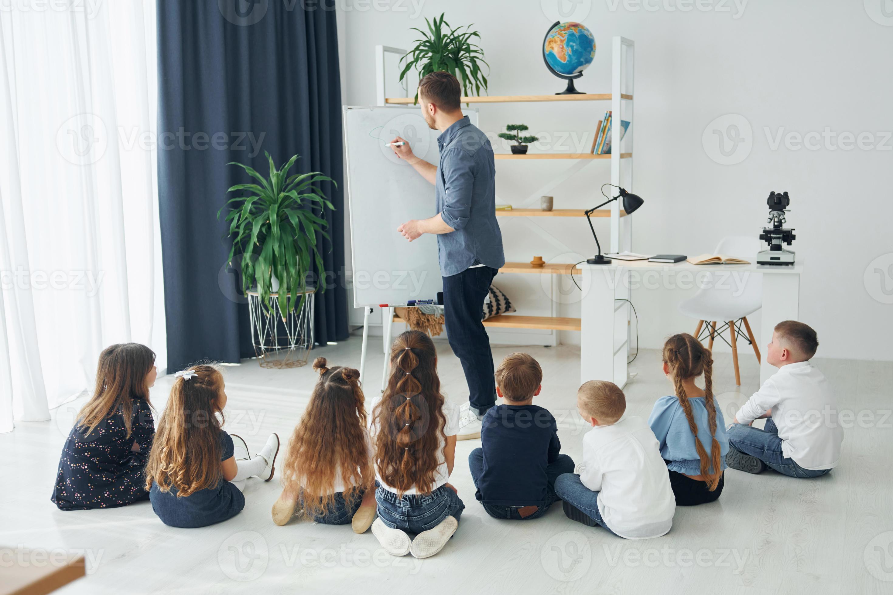 debout et expliquant la leçon à l'aide d'un tableau blanc. groupe