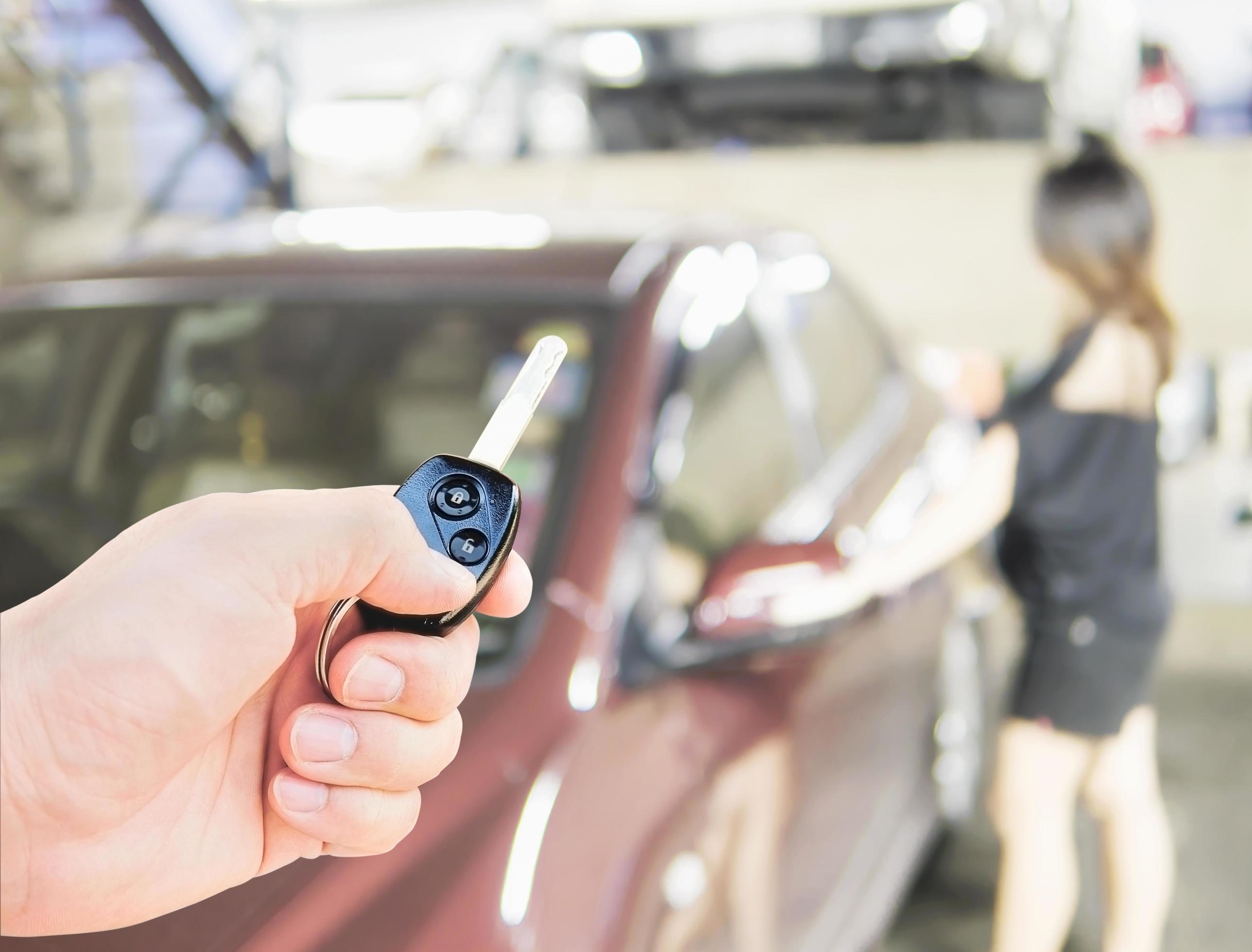 Un homme donne une clé de voiture avec un gros nœud rouge à une