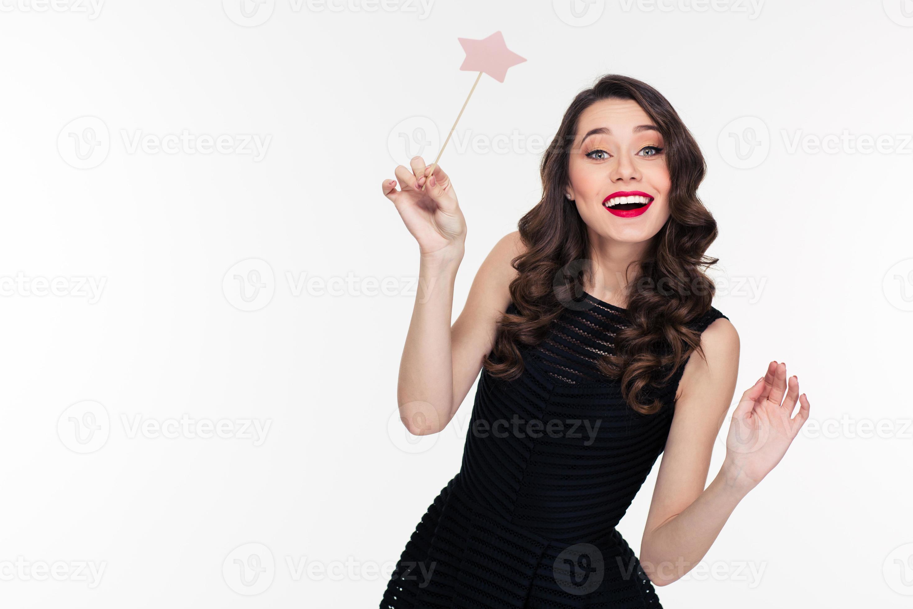 Joyeuse belle jeune femme frisée posant avec une baguette magique 945523  Photo de stock chez Vecteezy