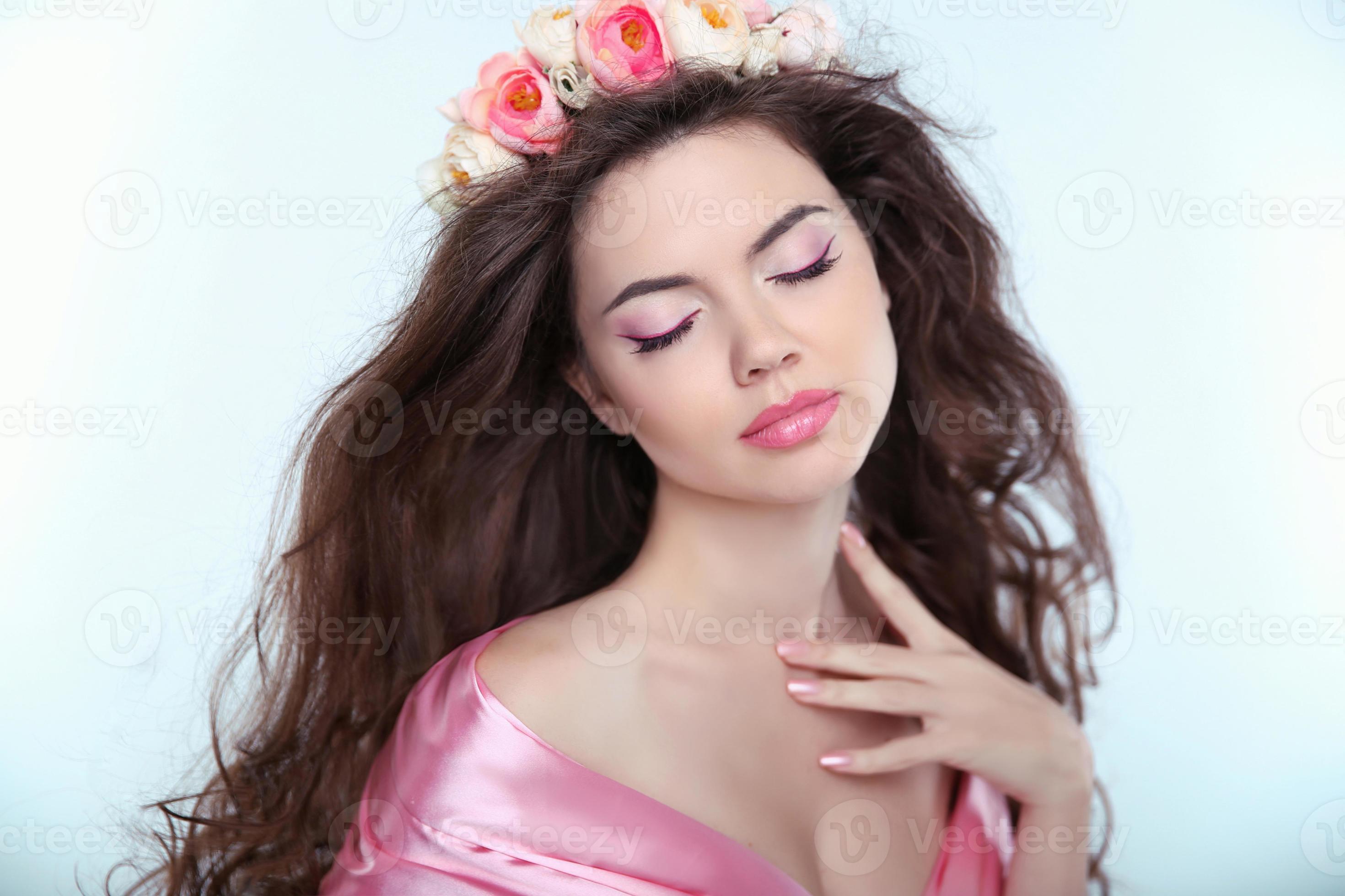 tendre belle fille avec des fleurs délicates dans de longs cheveux ondulés photo