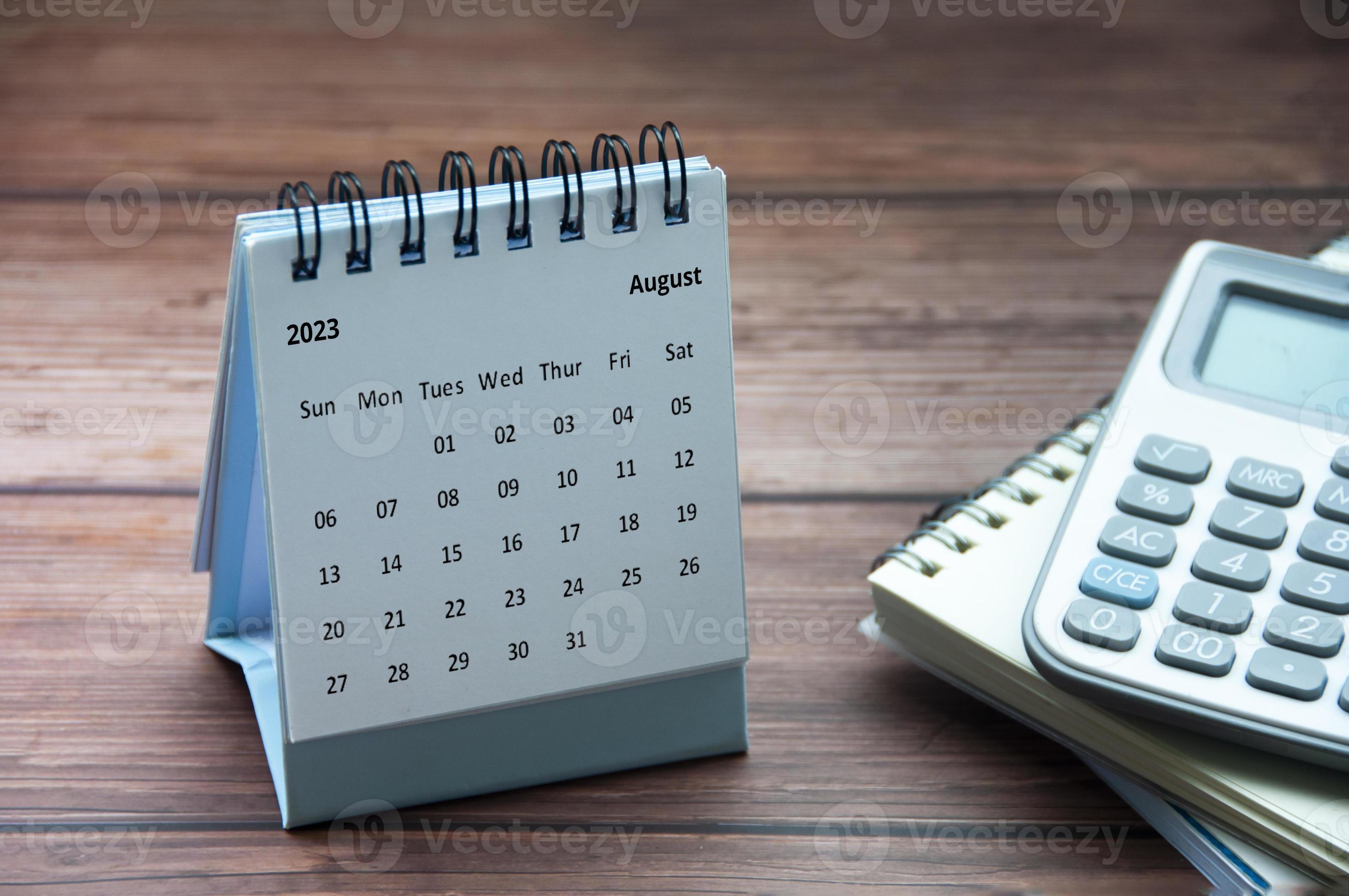 août 2023 calendrier de bureau blanc sur table en bois avec bloc-notes et  fond de calculatrice. 9532549 Photo de stock chez Vecteezy