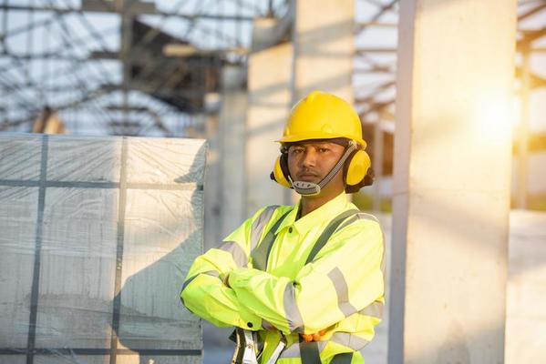 heureux ingénieur homme en casque et gilet de sécurité sur le chantier de  construction 6723138 Photo de stock chez Vecteezy