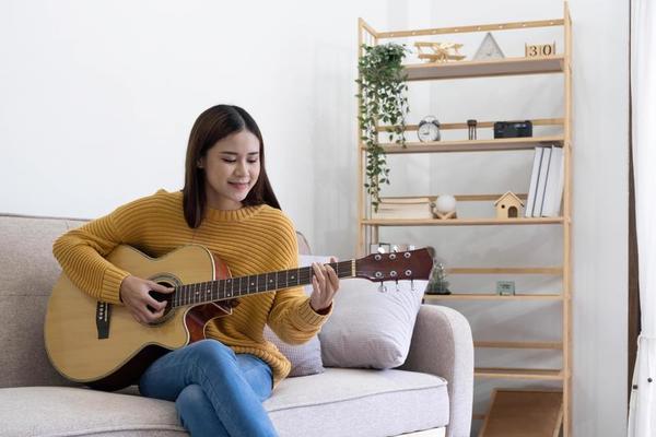 la fille s'est assise et a joué de la guitare sur le lit. 4890519 Photo de  stock chez Vecteezy