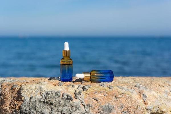 huiles essentielles naturelles ou sérum dans des flacons compte-gouttes  bruns posés sur les pierres au bord de la mer 11740795 Photo de stock chez  Vecteezy