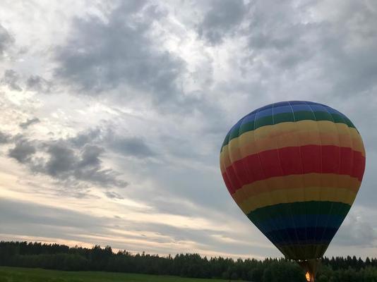 Grand ballon volant multicolore à rayures rondes et lumineuses de couleur  arc-en-ciel avec un panier contre le ciel le soir 14275344 Photo de stock  chez Vecteezy
