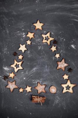 cuisson comme arbre de noël sur une plaque brune, biscuits en forme d'étoile,  noix, cannelle sur une table en bois blanche. 15473435 Photo de stock chez  Vecteezy