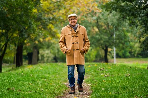 Extérieur portrait de une Sénior homme dans hiver manteau avec une