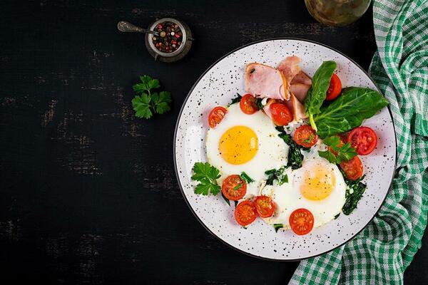 assiette avec une céto régime aliments. frit œuf, jambon, épinard, et  tomates. céto, paléo petit déjeuner. Haut voir, copie espace 26717320 Photo  de stock chez Vecteezy