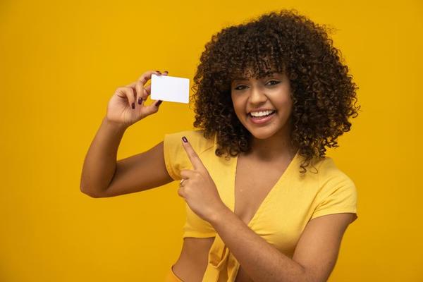 la main de la jeune femme tient une maquette de carte blanche vierge avec  des coins arrondis. modèle de maquette de carte d'appel simple tenant le  bras. carte de crédit en plastique sur le devant. vérifier la conception de  la carte offset. l'image de marque