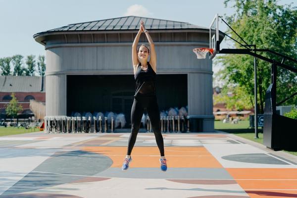 le modèle féminin actif positif a un entraînement cardio à l'extérieur  saute haut garde les