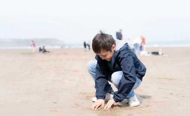 garçons heureux faisant un château de sable sur la plage