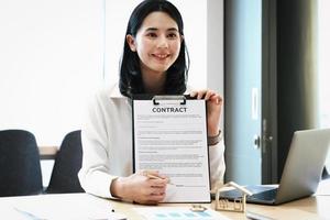 l'agent immobilier donne un accord de stylo et de documents avec le client pour signer le contrat. accord de concept. photo