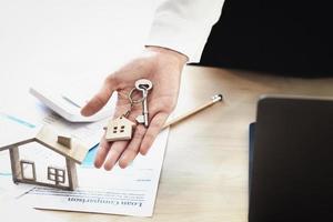les agents immobiliers acceptent d'acheter une maison et remettent les clés aux clients dans les bureaux de leur agence. accord de concept. photo