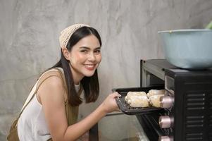 belle jeune femme cuisine dans sa cuisine, sa boulangerie et son café photo