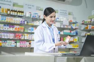 une pharmacienne conseillant une cliente par appel vidéo dans une pharmacie de pharmacie moderne. photo